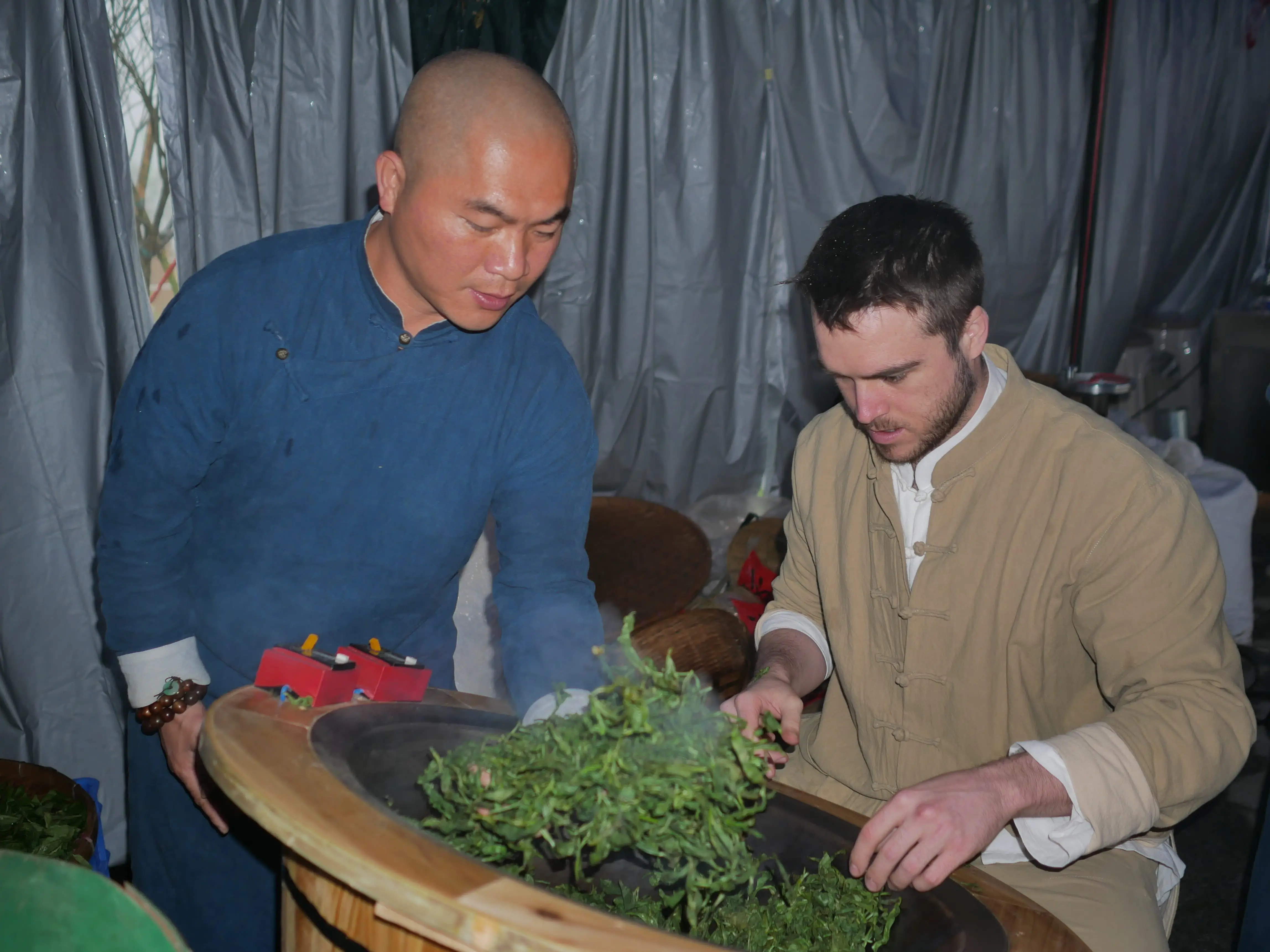 Tea master and roeginer looking over tea in Guangdong , China.