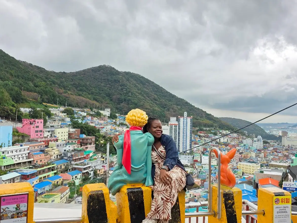 A woman posing with a famous Little Prince statue in Busan, South Korea.