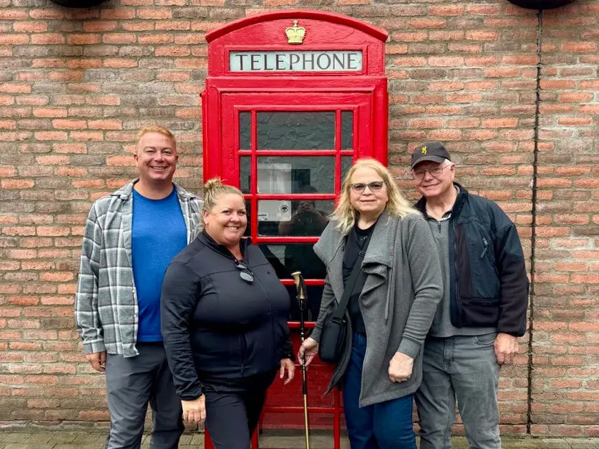 Author, husband, and in-laws posing with phone booth