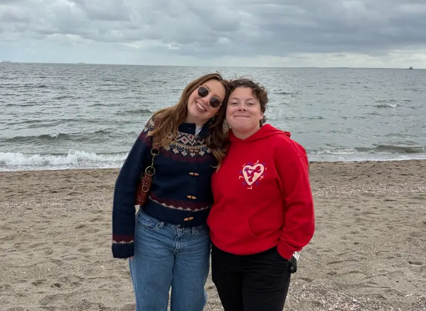 The writer and her partner standing at the beach in her partner's hometown.