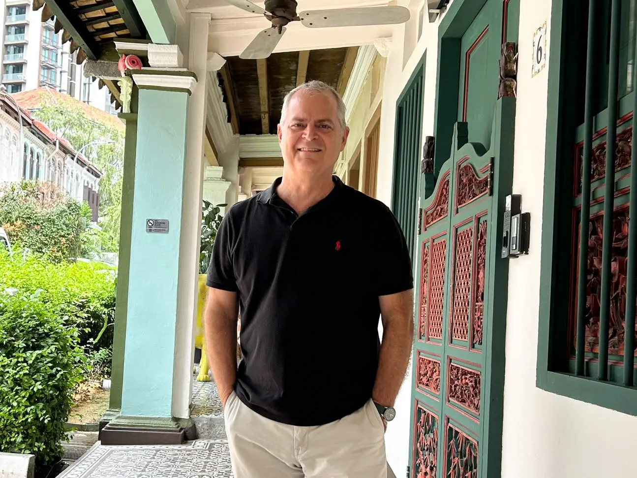 Kris LeBoutillier  standing near a shophouse in Singapore.