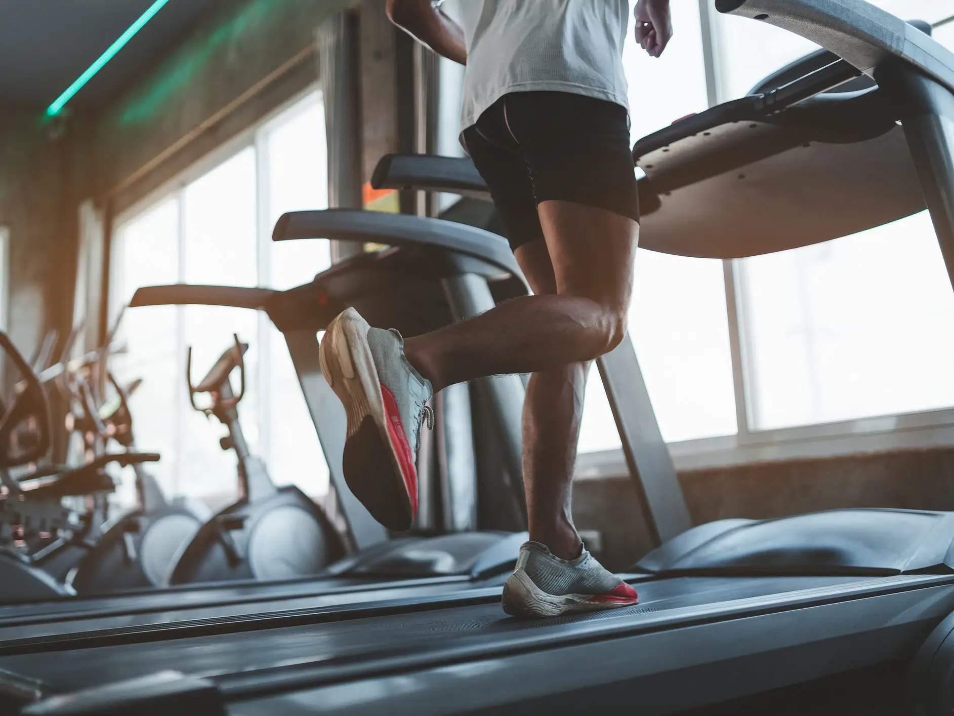 Close-up of a person running on a treadmill in a fitness club.