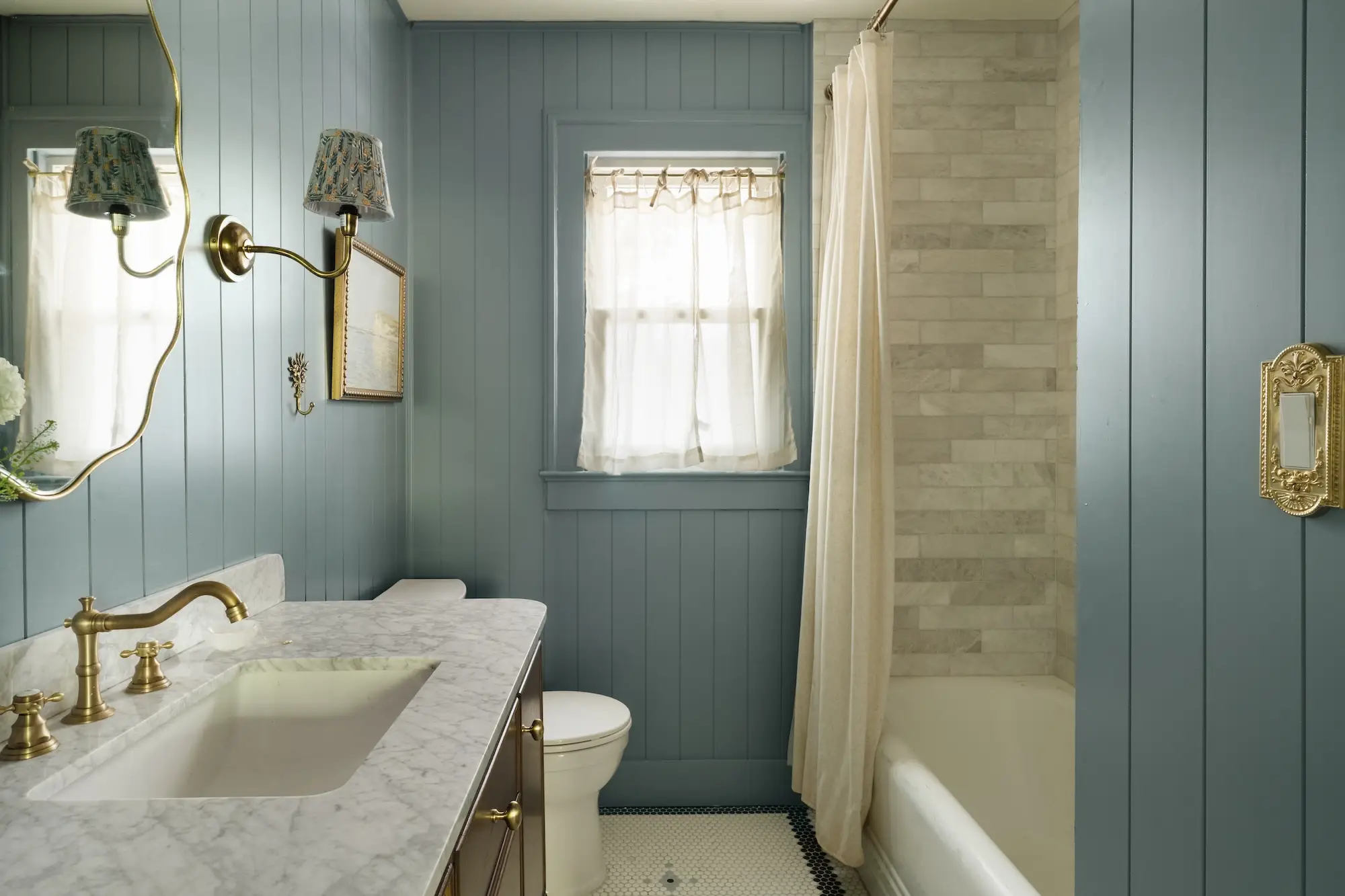 A bathroom with blue shiplap walls.