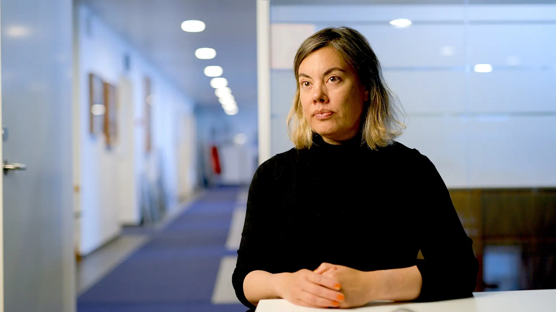 Greenland minister Naaja Nathanielsen in a black shirt in an office setting.