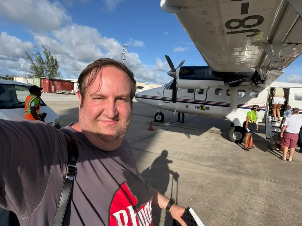 Author David Morris smiling next to plane