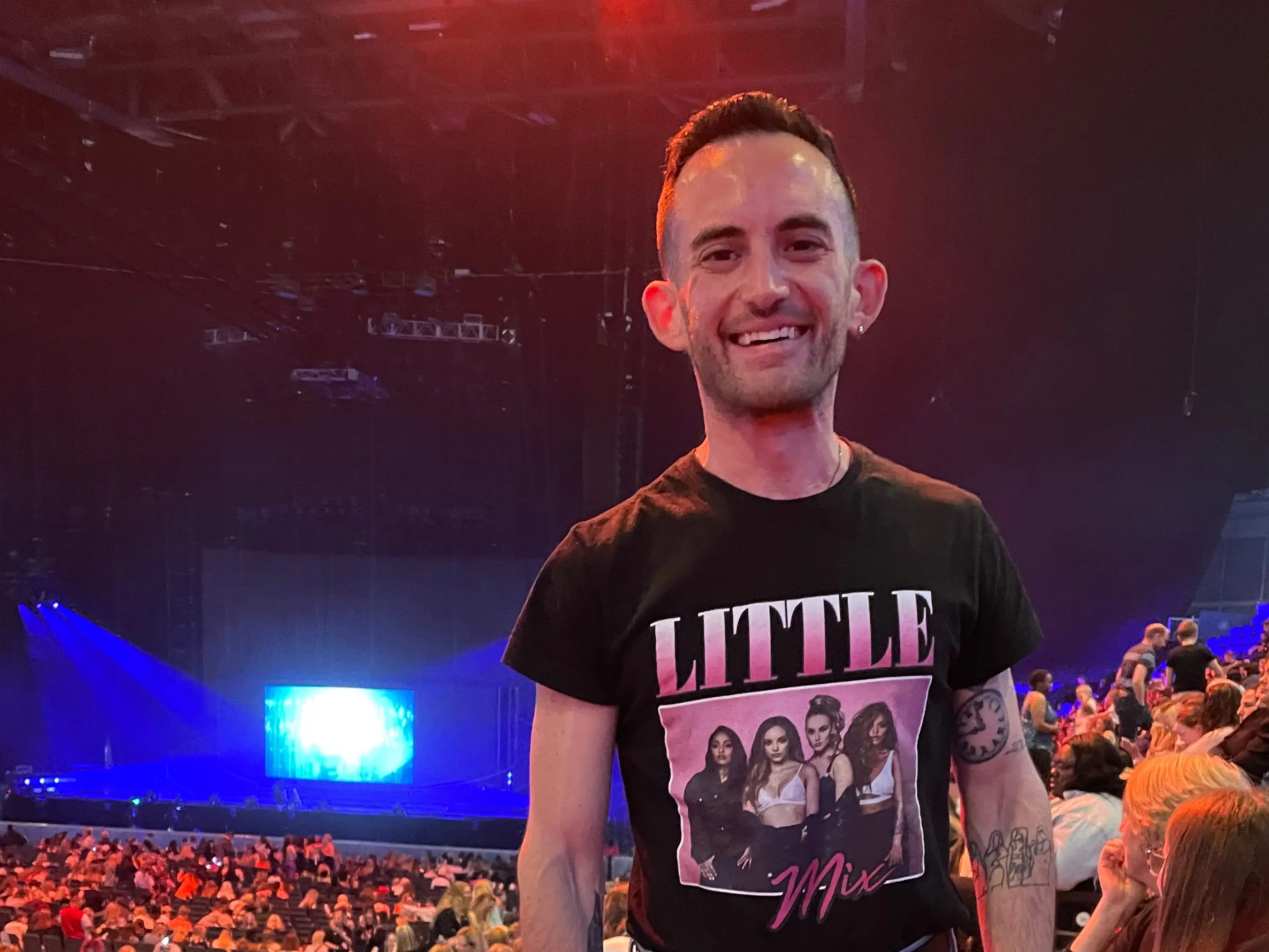 The author smiling at his seat before a Little Mix concert.