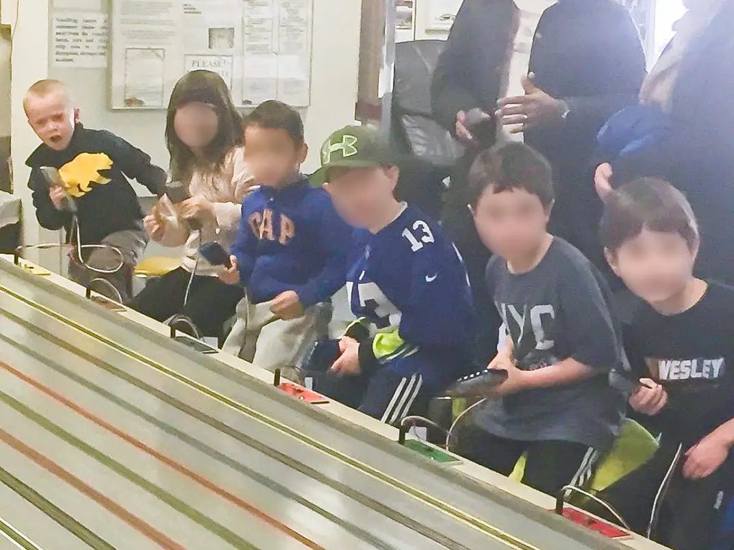 A group of children at a slot-car racing track.