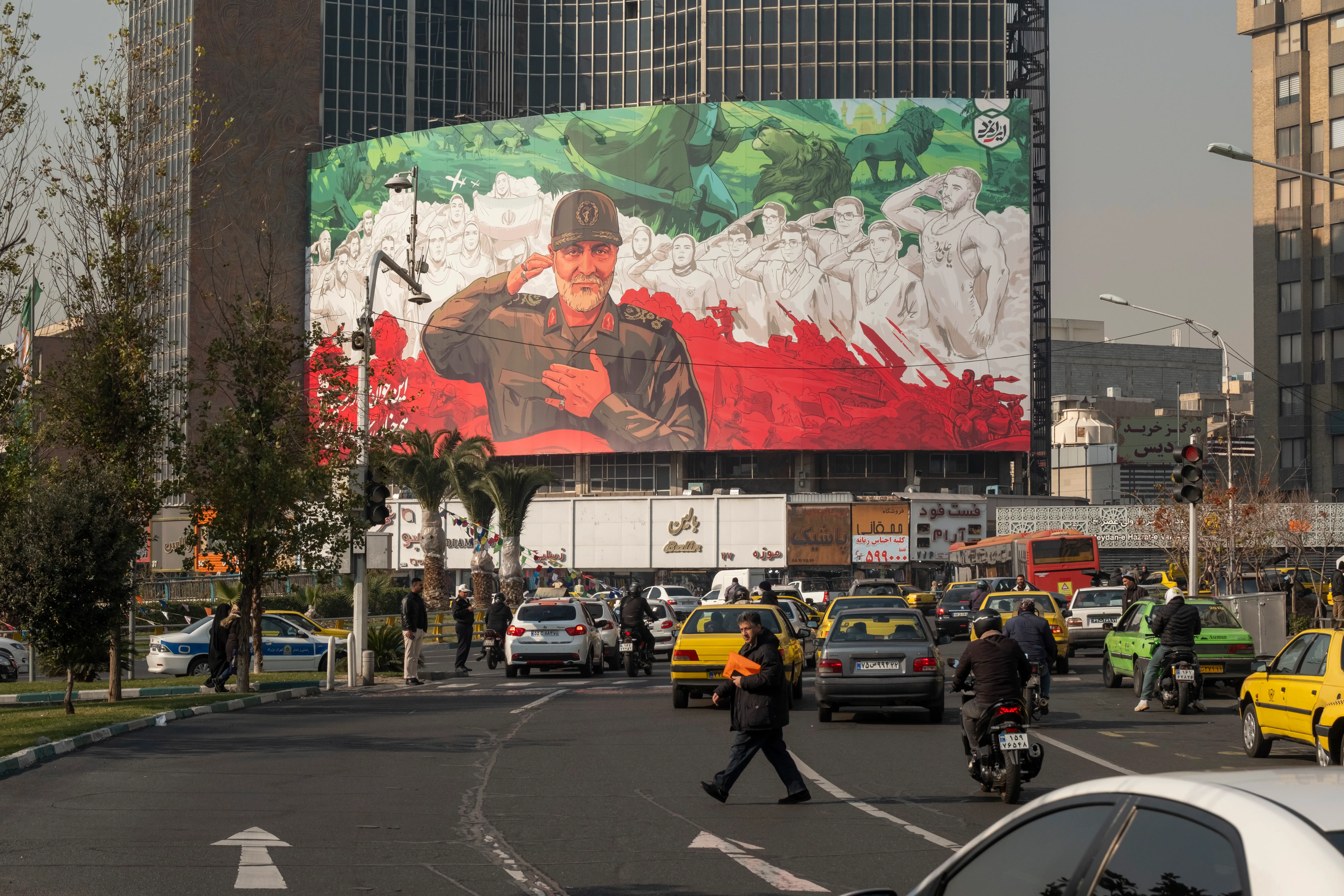 A billboard depicting symbolic images of the former commander of the Islamic Revolutionary Guard Corps (IRGC) Quds Force, Major General Qassem Soleimani, and Iranian athletes is hung on a state building in downtown Tehran, Iran, on January 6, 2026.