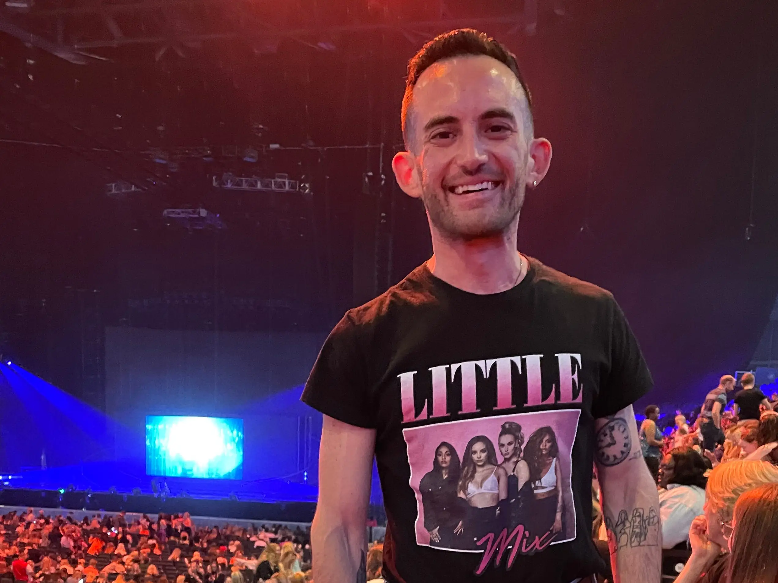 The author smiling at his seat before a Little Mix concert.
