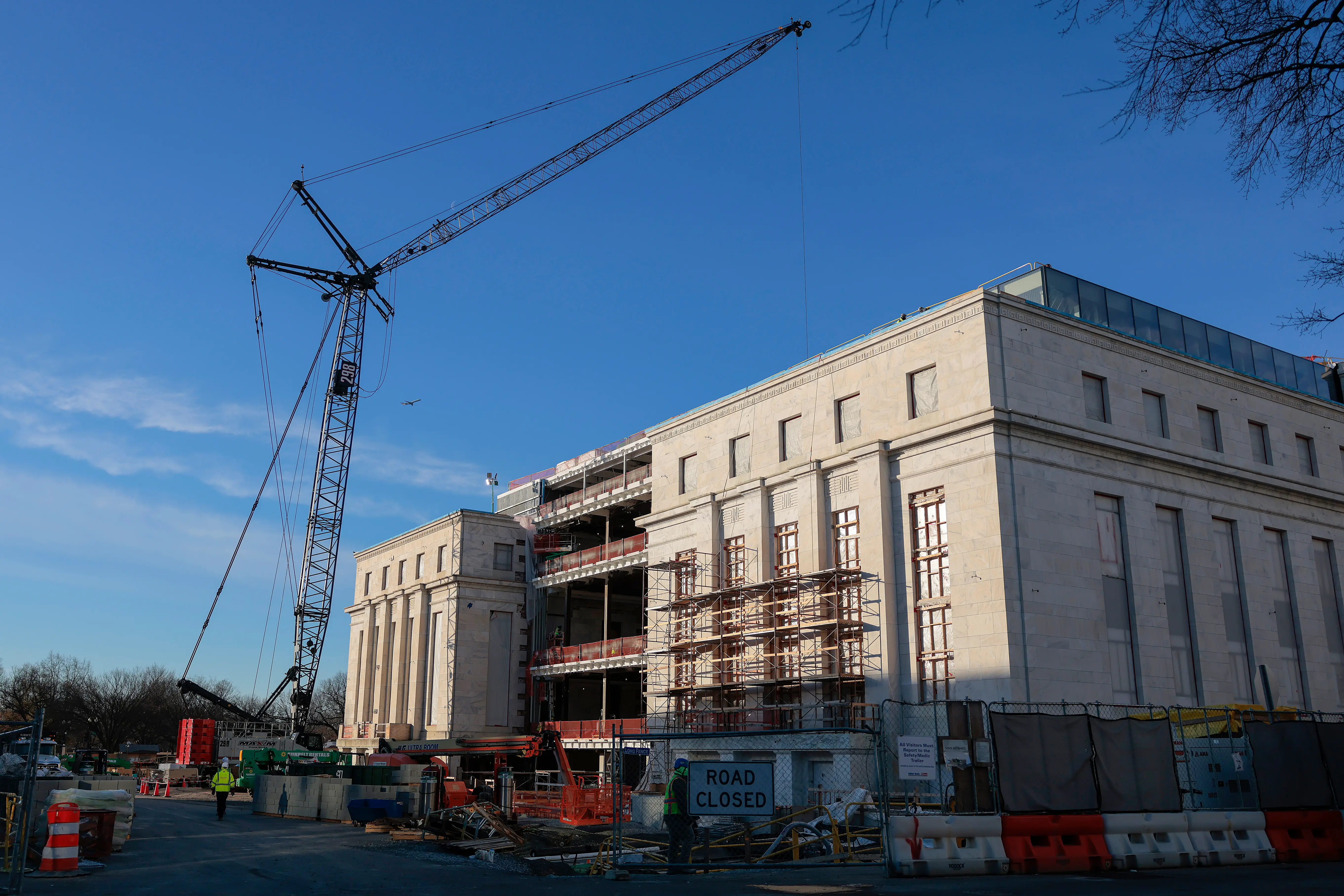 Scaffolding cranes tower over the Fed's building as scaffolding wraps around the office's exterior.