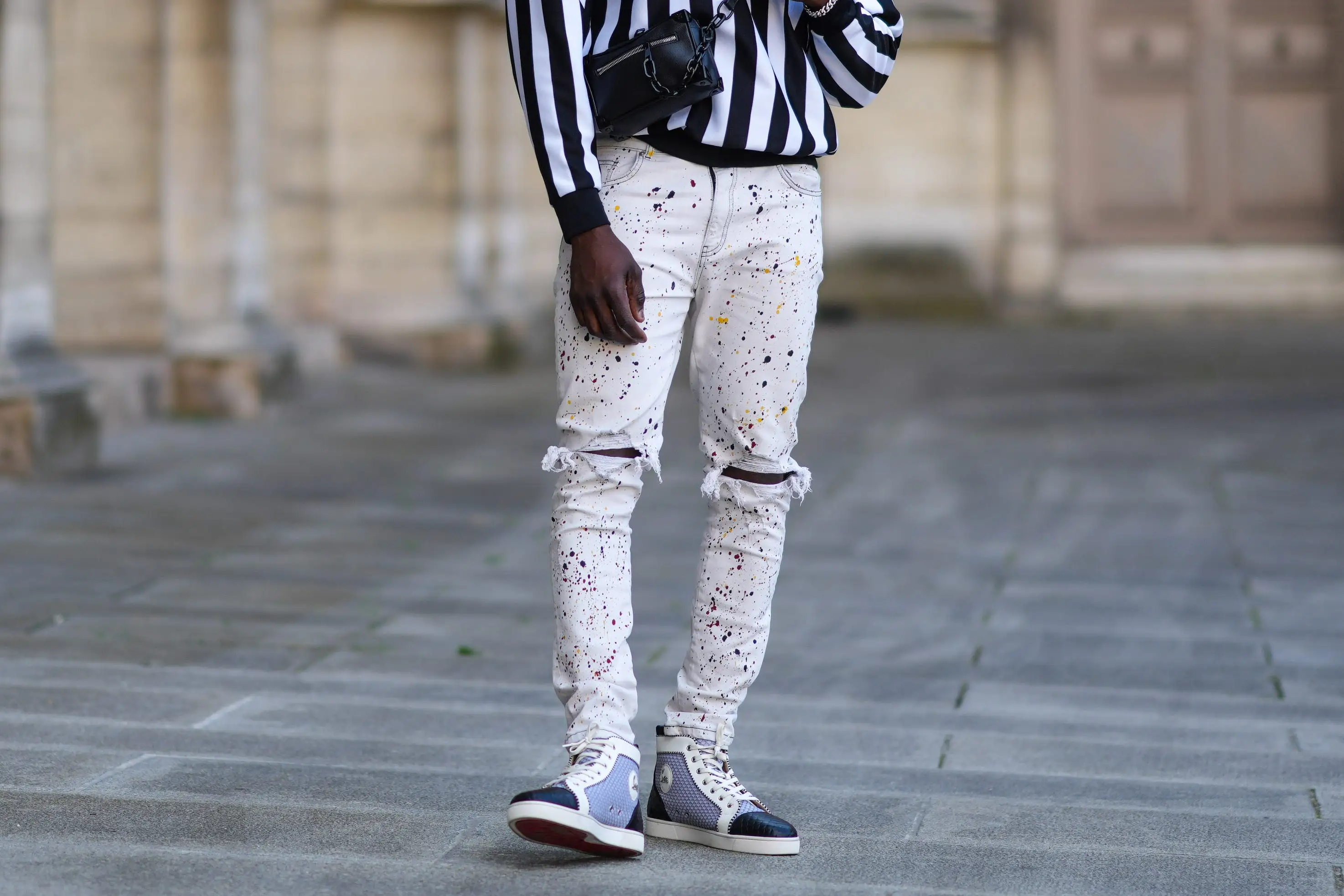 Man wearing ripped jeans, stripped shirt