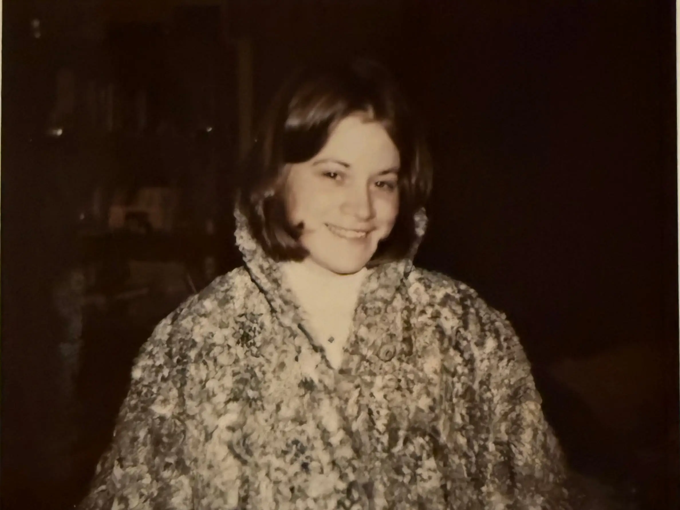 A black and white photo of a teenager wearing a thick coat