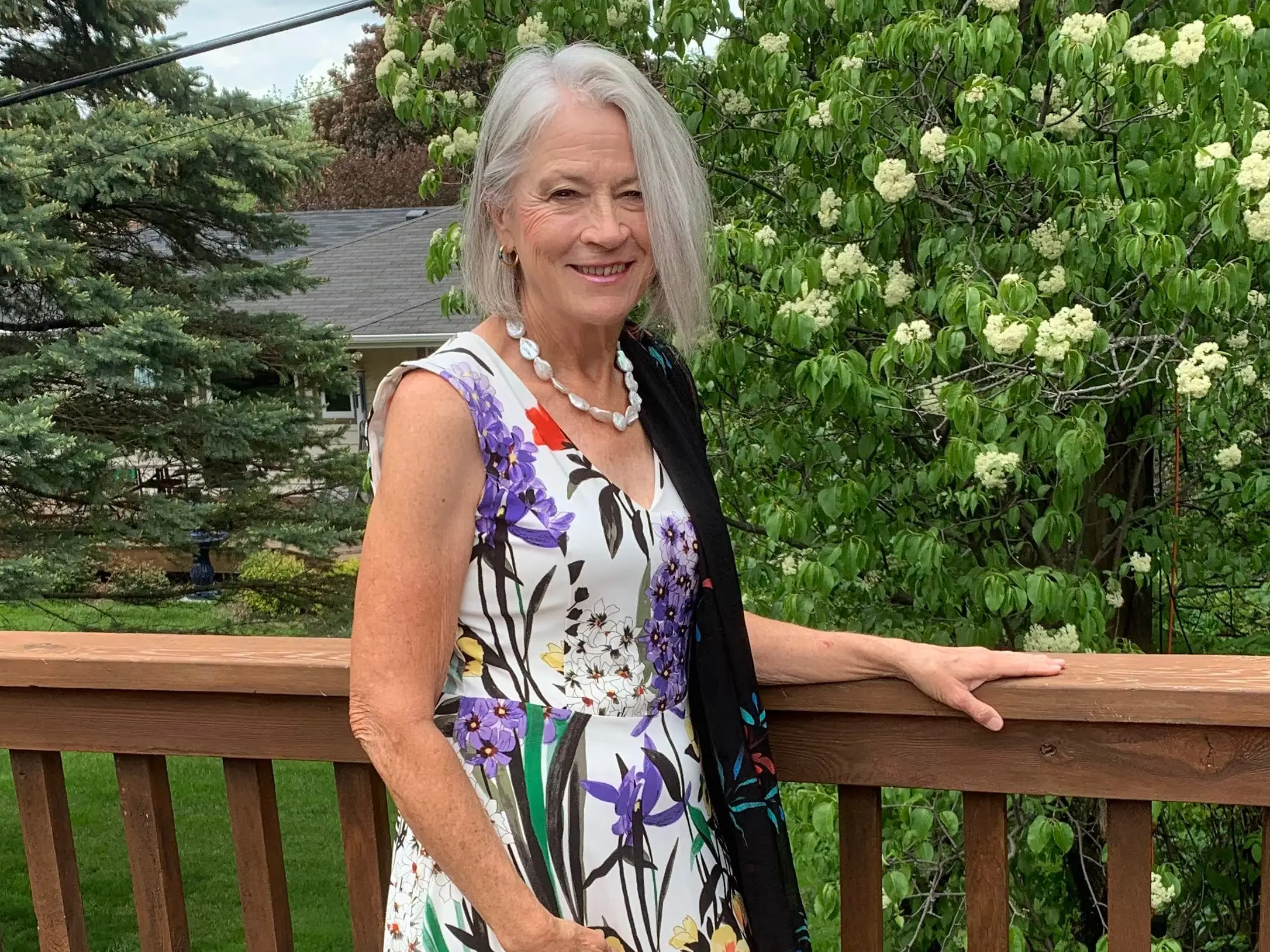 A woman in a flowered dress standing on a deck