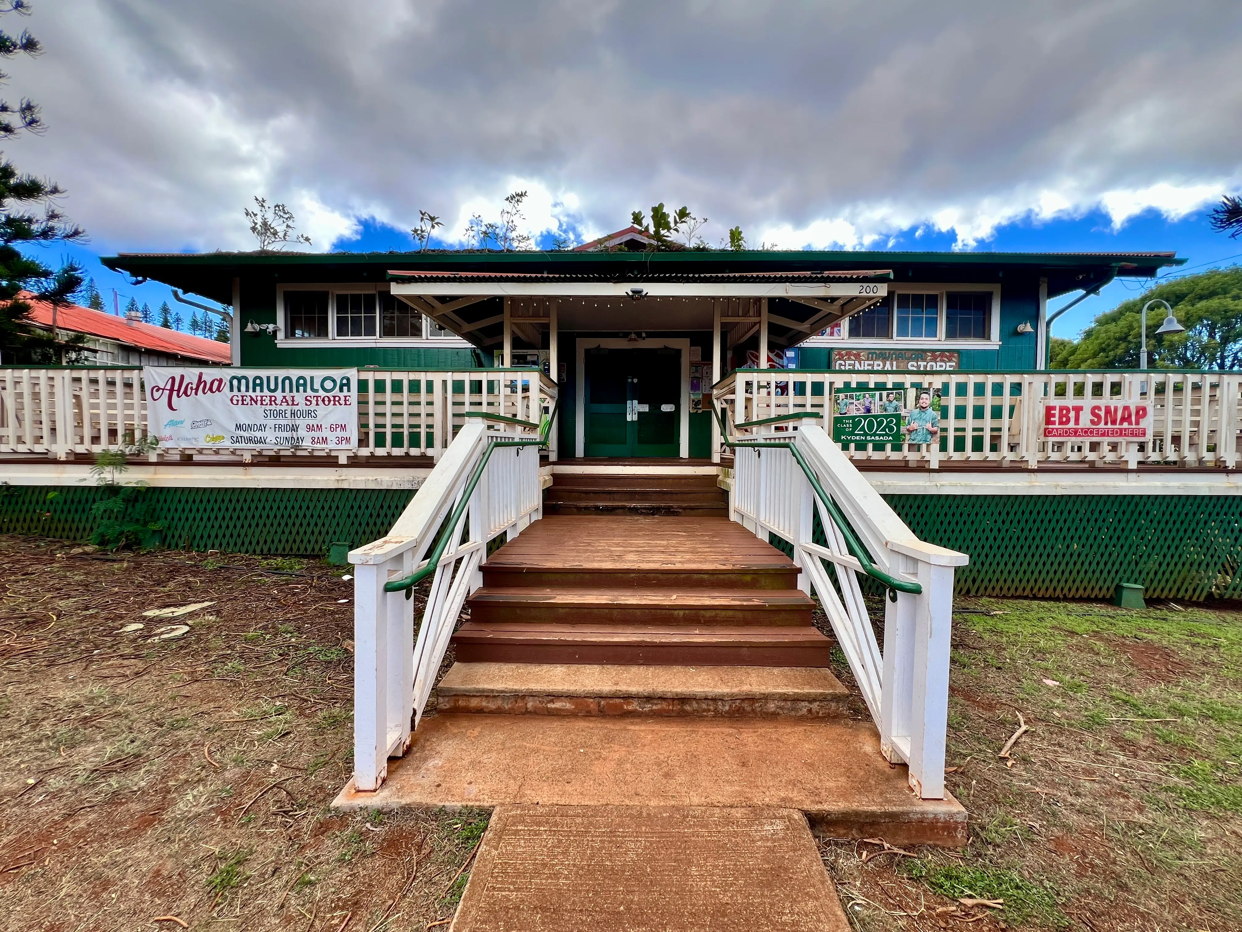 Aloha Maunaloa General store exterior, green building with brown steps