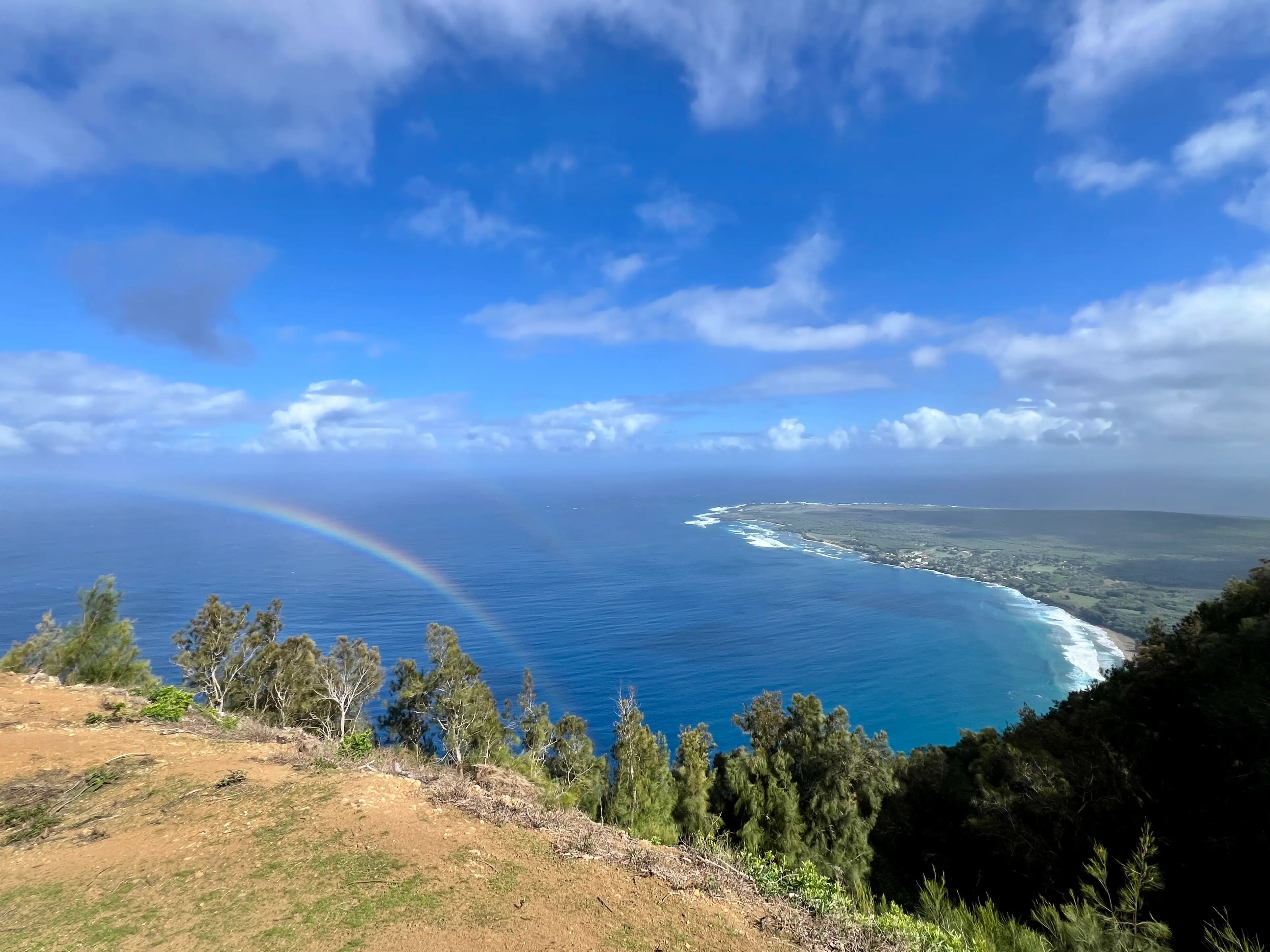 View over clear blue waters with rainbow over them