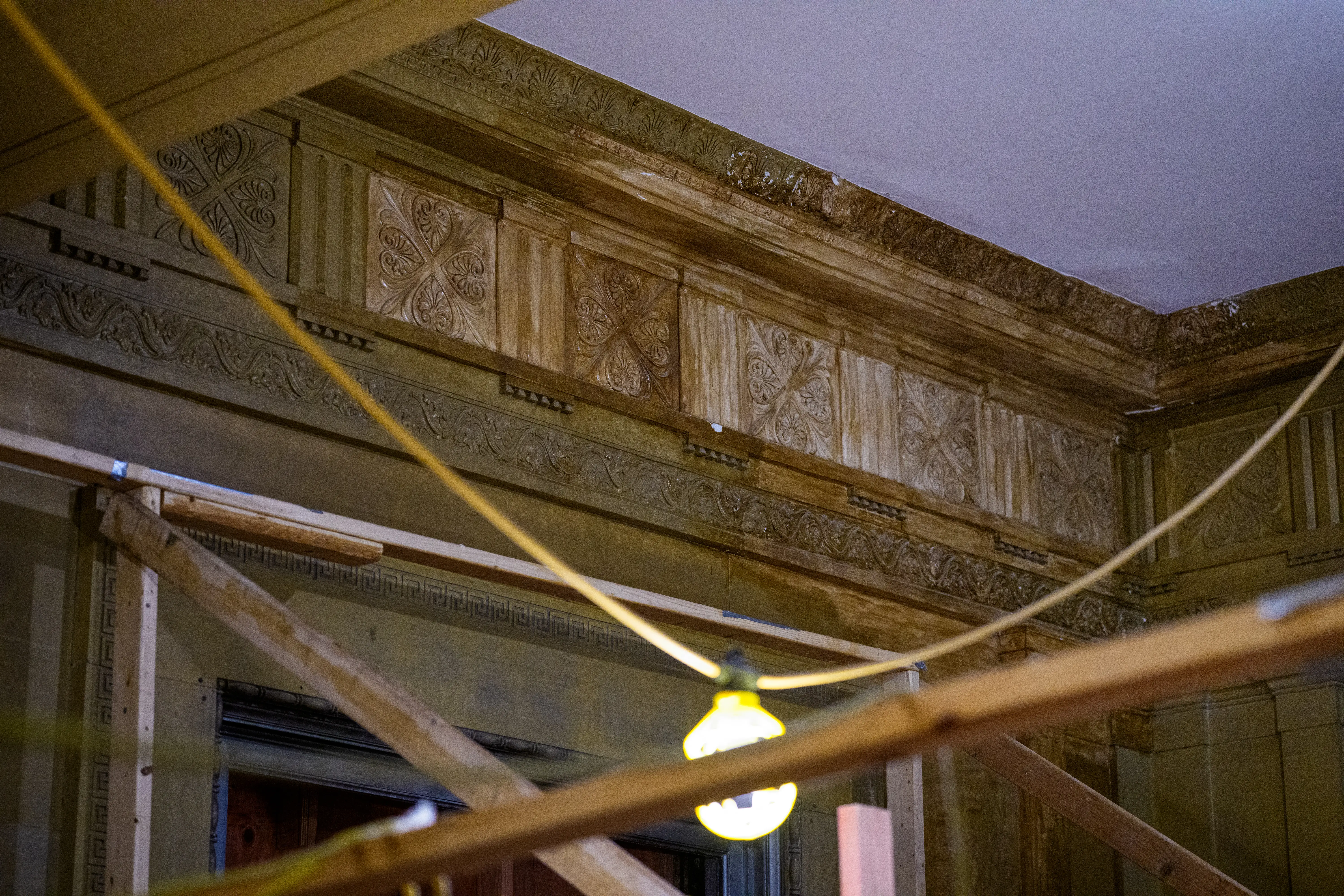 Ornate wood that was hand-crafted during the building's construction in the 1930s shows water damage
