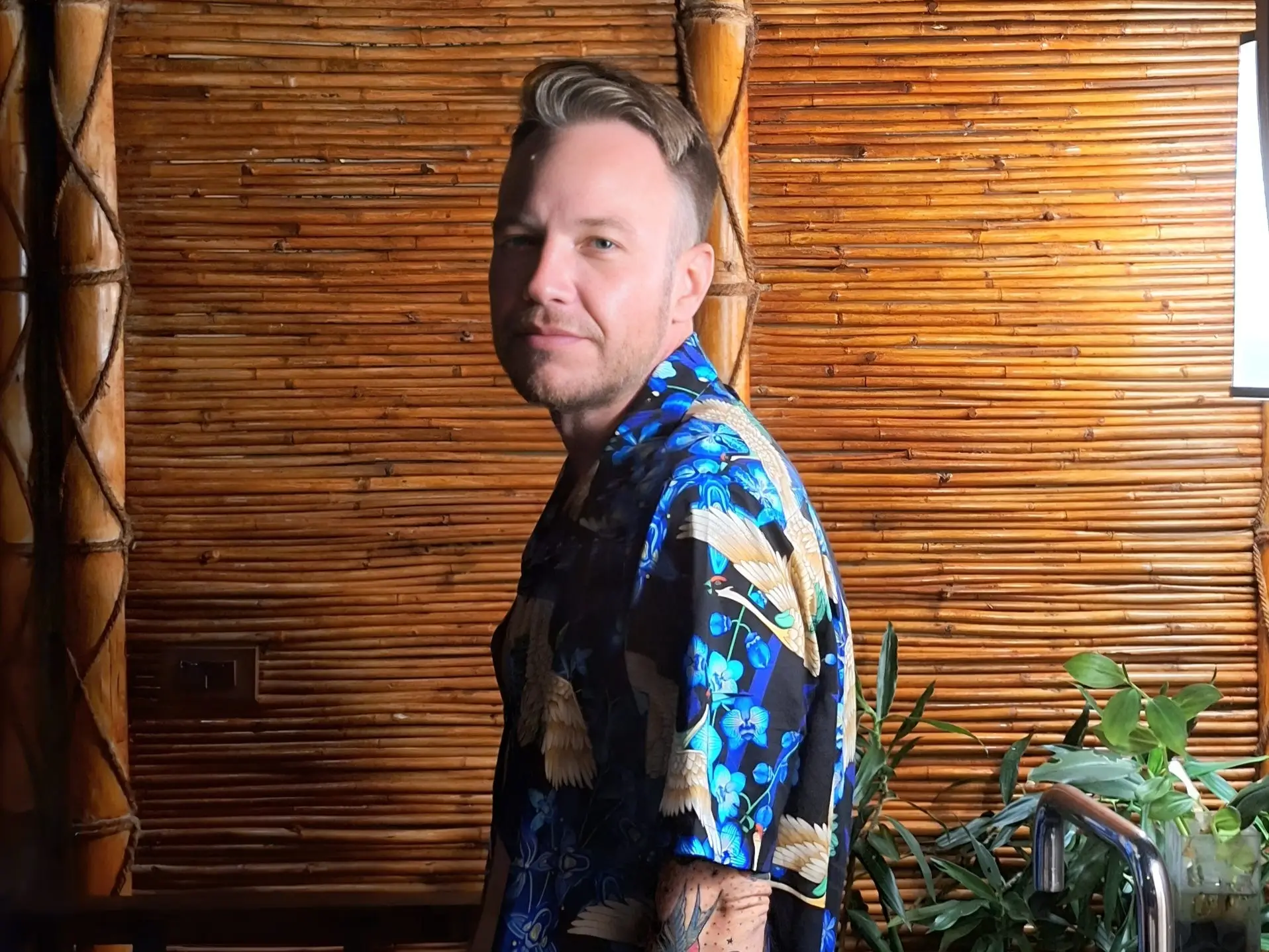 Andre Neveling posing with a bamboo wall in the background.