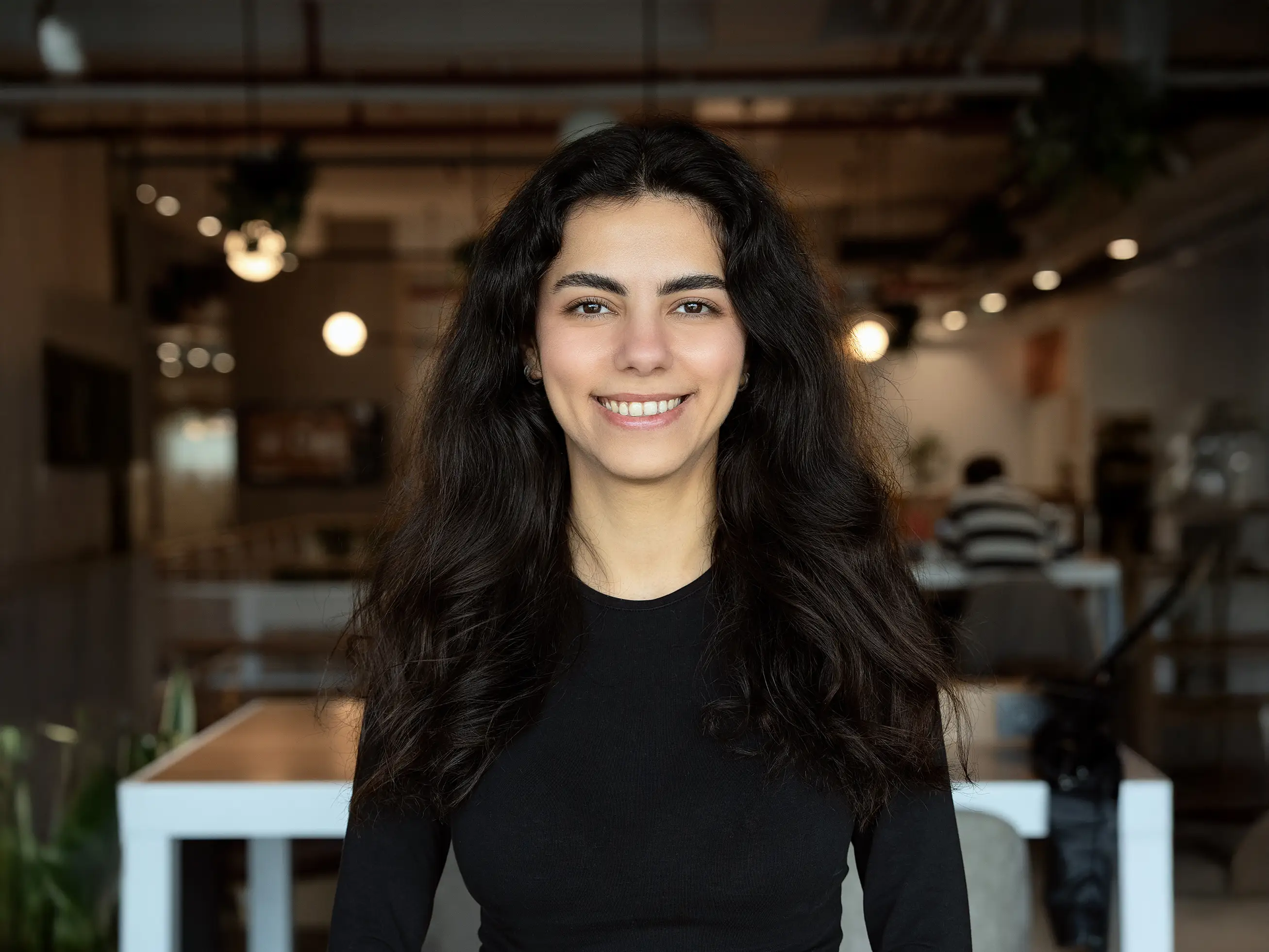 Irem Sumer, the CEO of Talemonster Games. Sumer has her hair down and is wearing a black long-sleeved shirt..