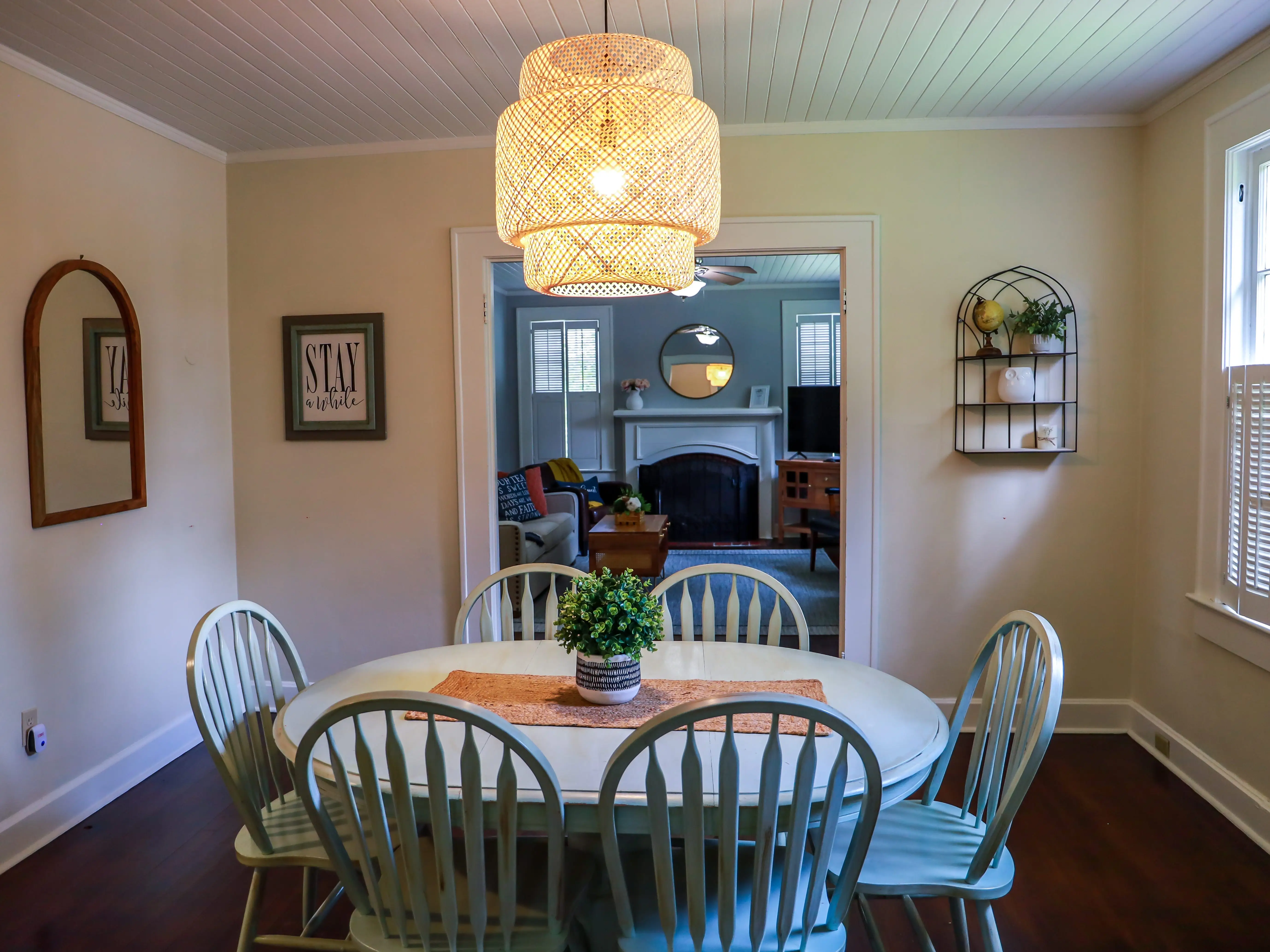 A rattan light fixture above a dining room table.