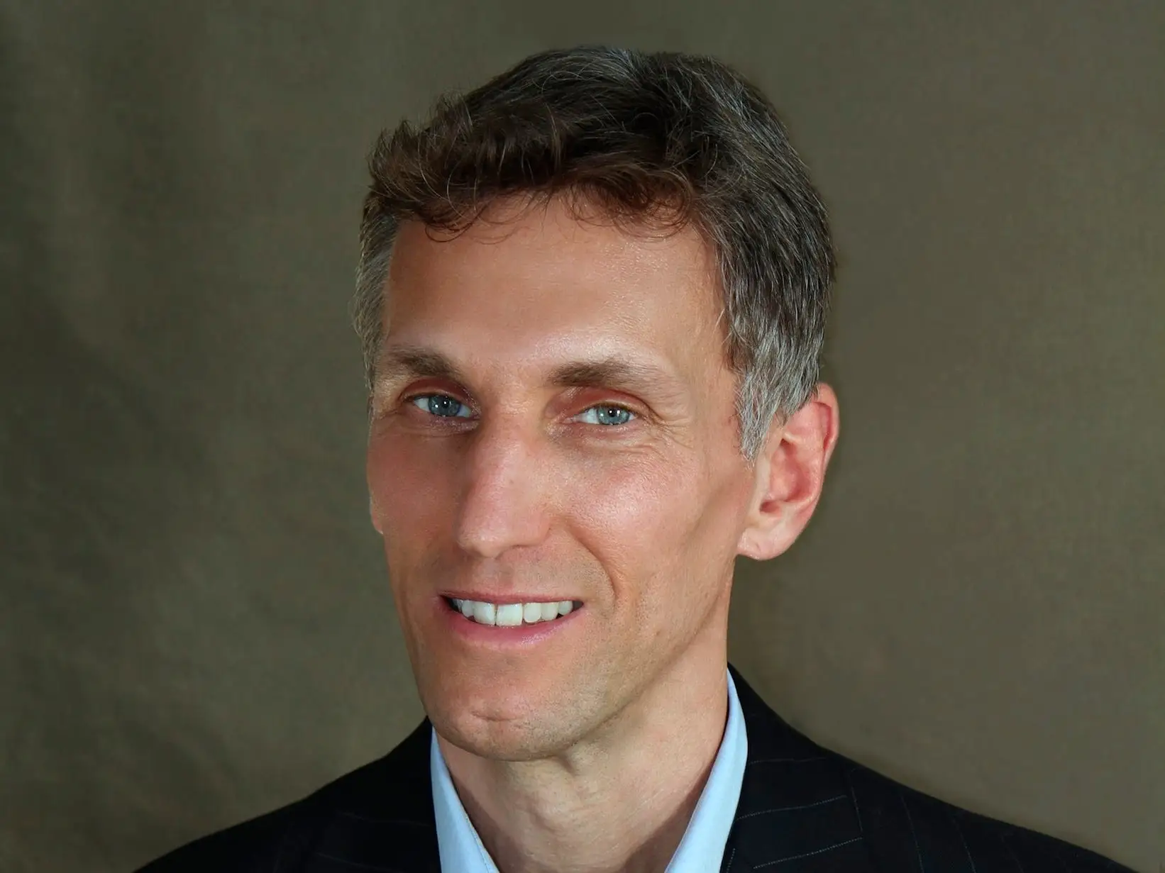 headshot of a man in a pin stripe jacket