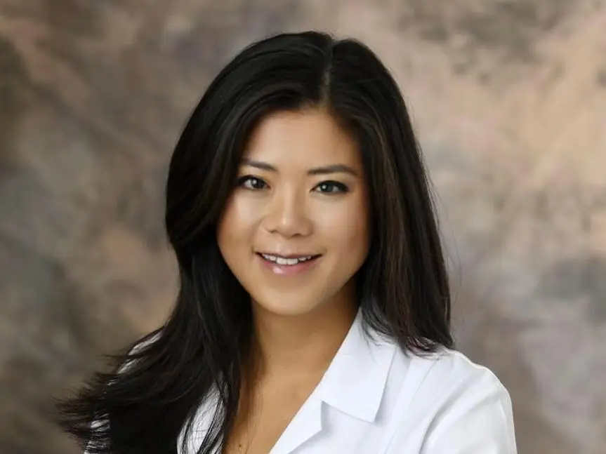 Dr. Sue Hwang in a white doctors coat smiling for a professional portrait