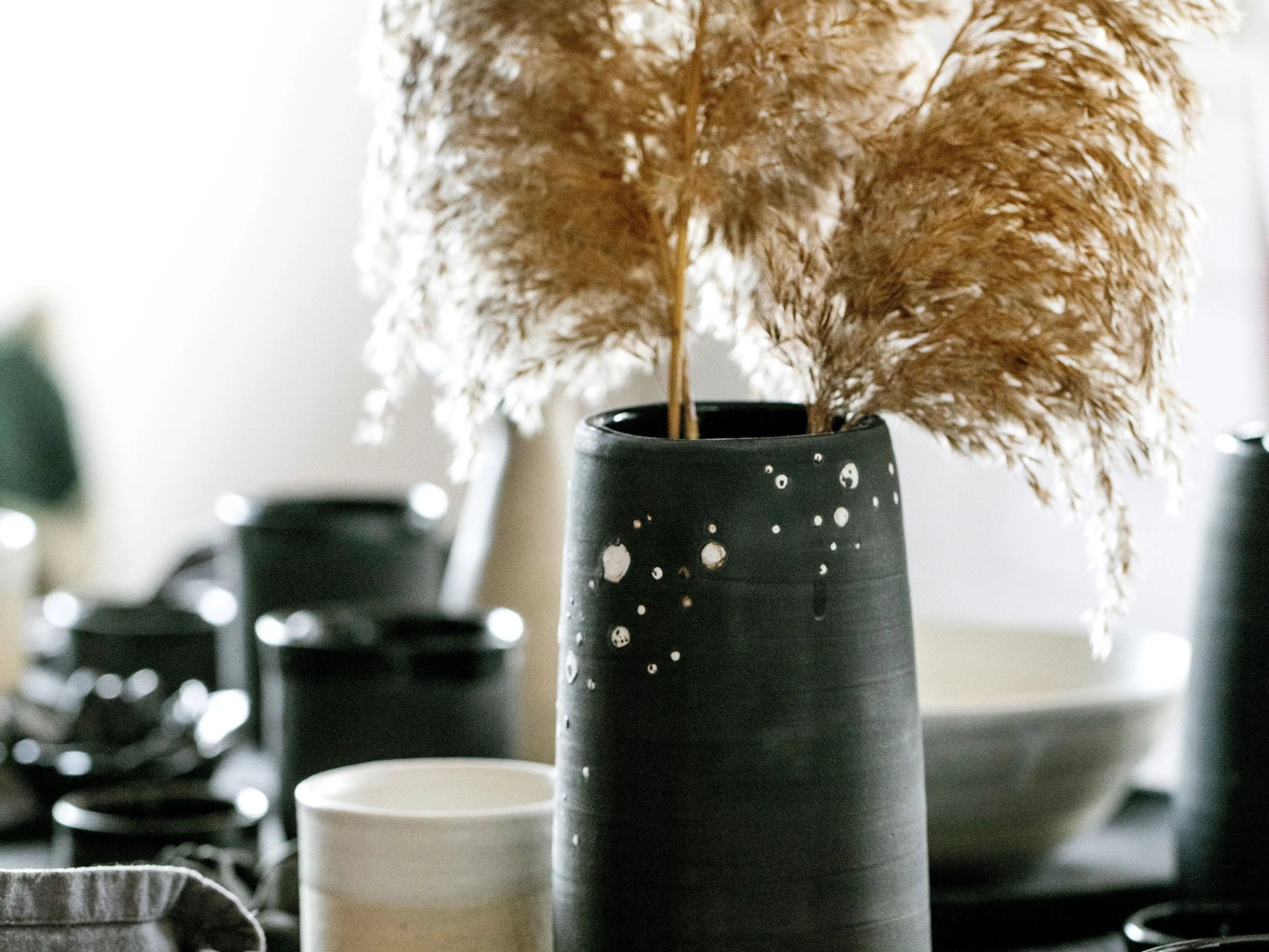 A tablescape with ceramic vases, mugs, and plates.
