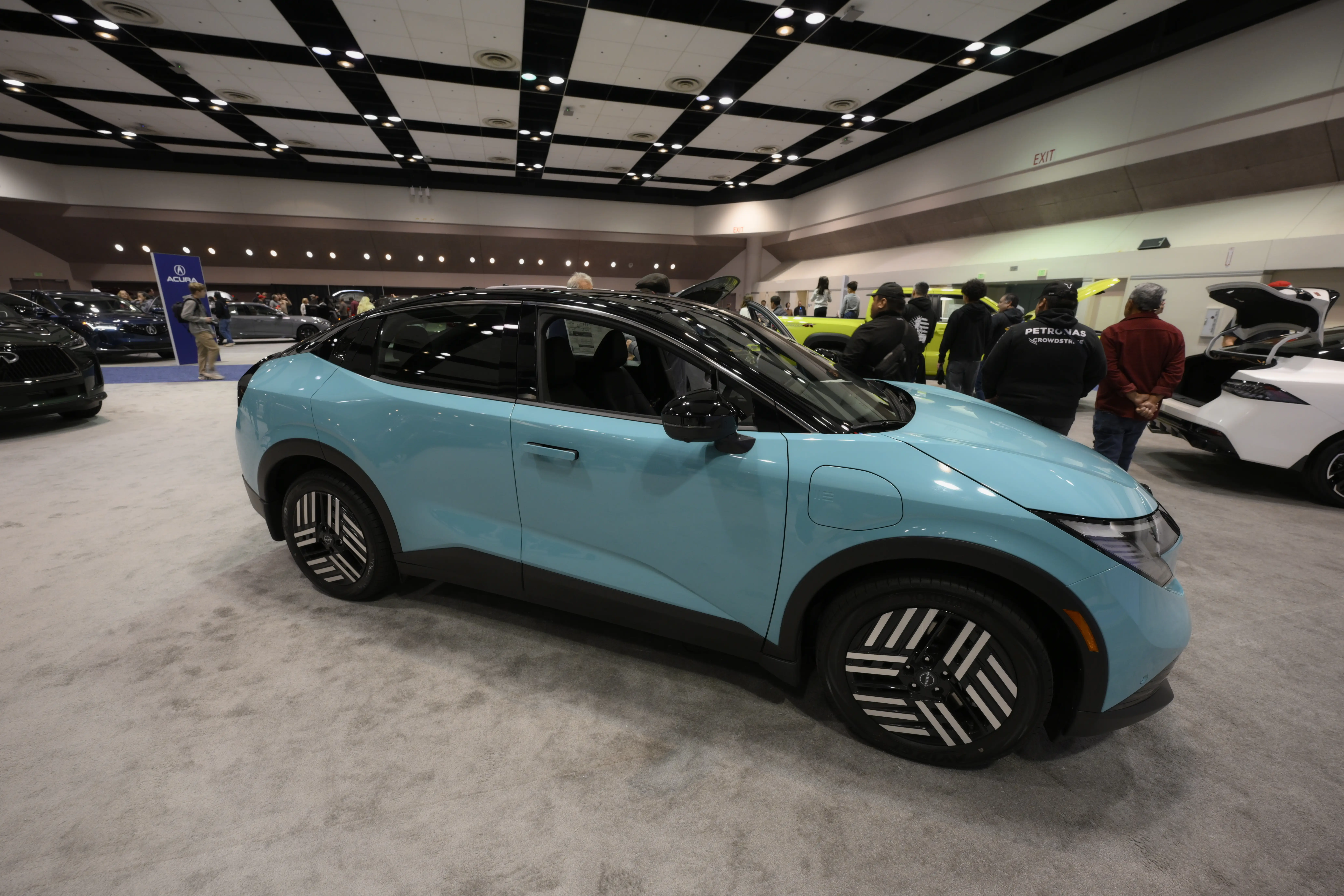 A light blue Nissan Leaf on a carpeted floor at the Silicon Valley Auto Show.