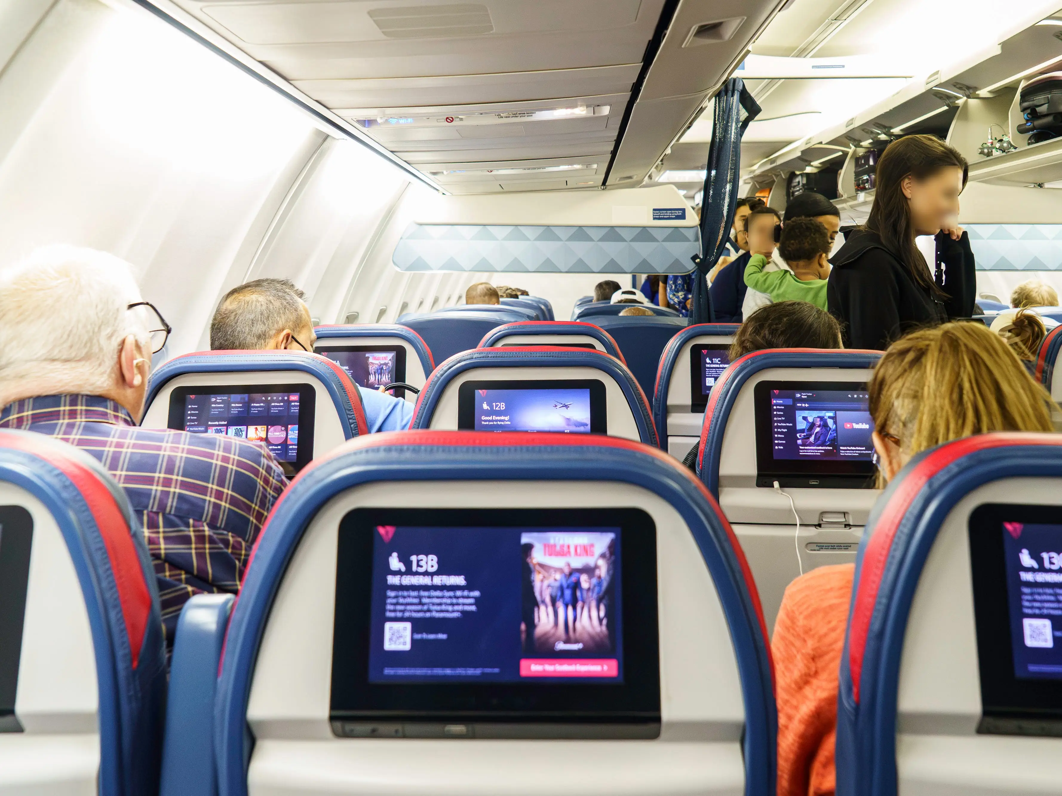 People board a Delta flight in the premium economy section