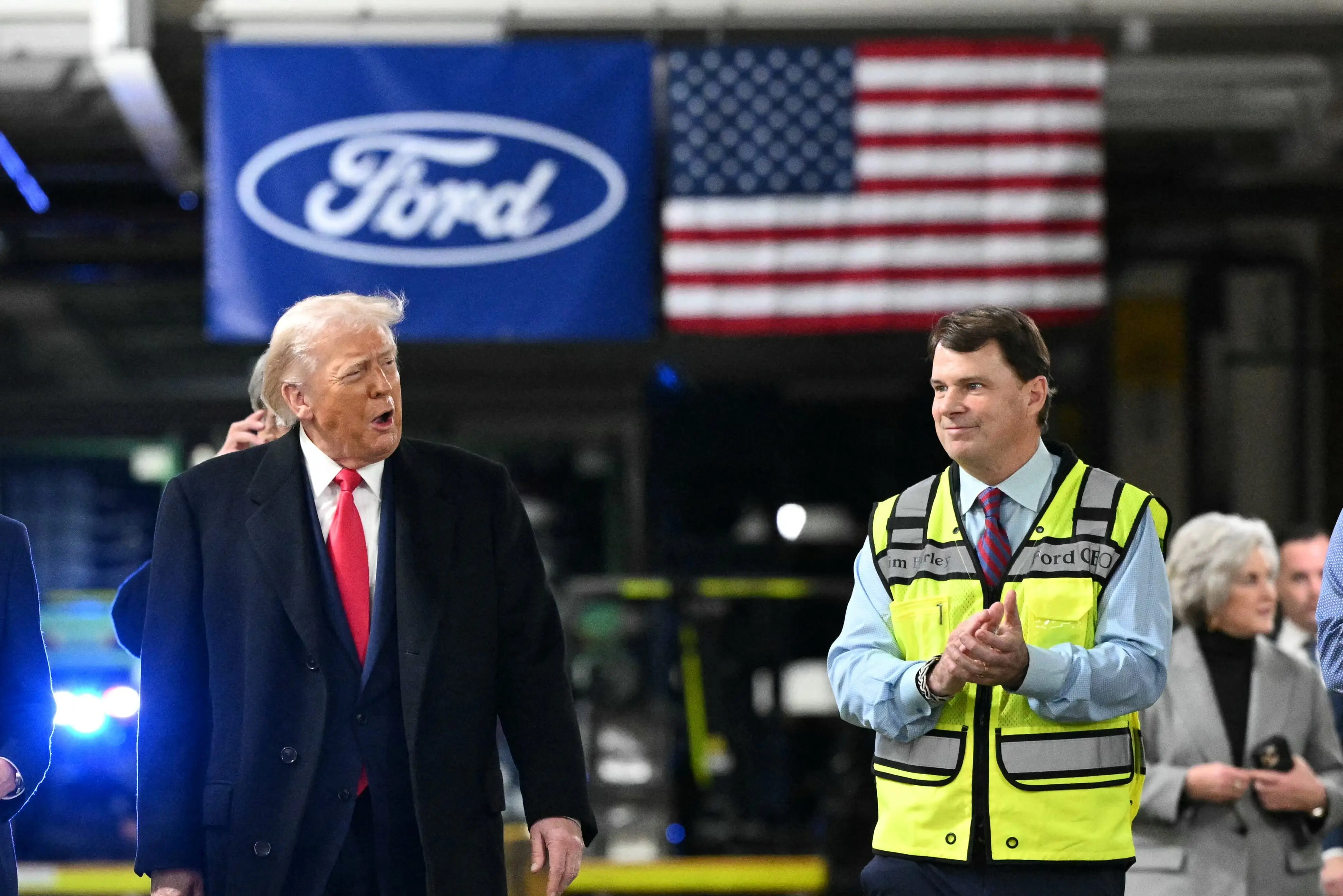 President Donald Trump (left) walks next to a highlight-green-vested Jim Farley, Ford's CEO, at the company's truck plant in Dearborn, Michigan.