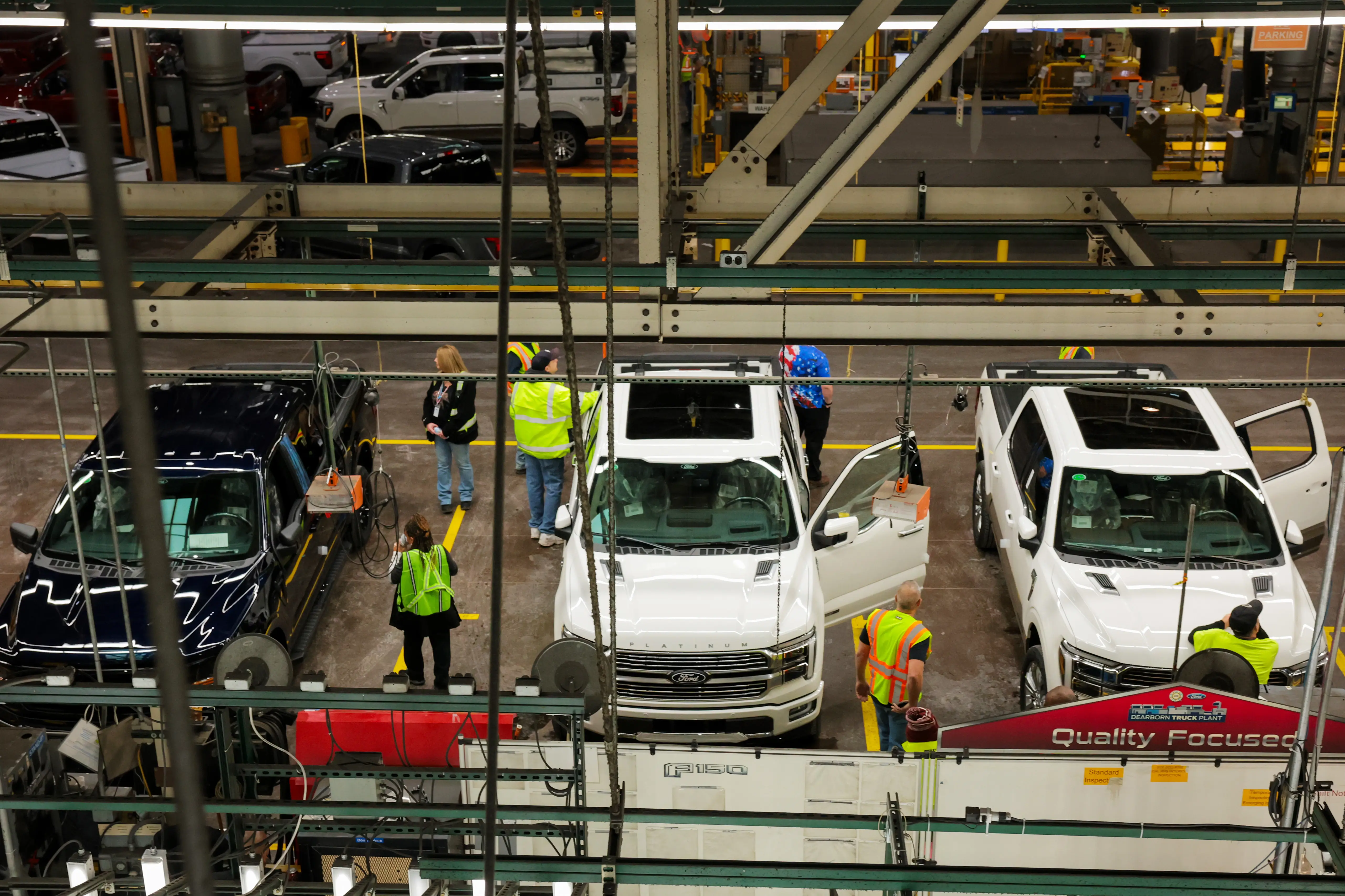 Three Ford F-150 pickup trucks displayed on Ford's assembly line in Dearborn, Michigan.