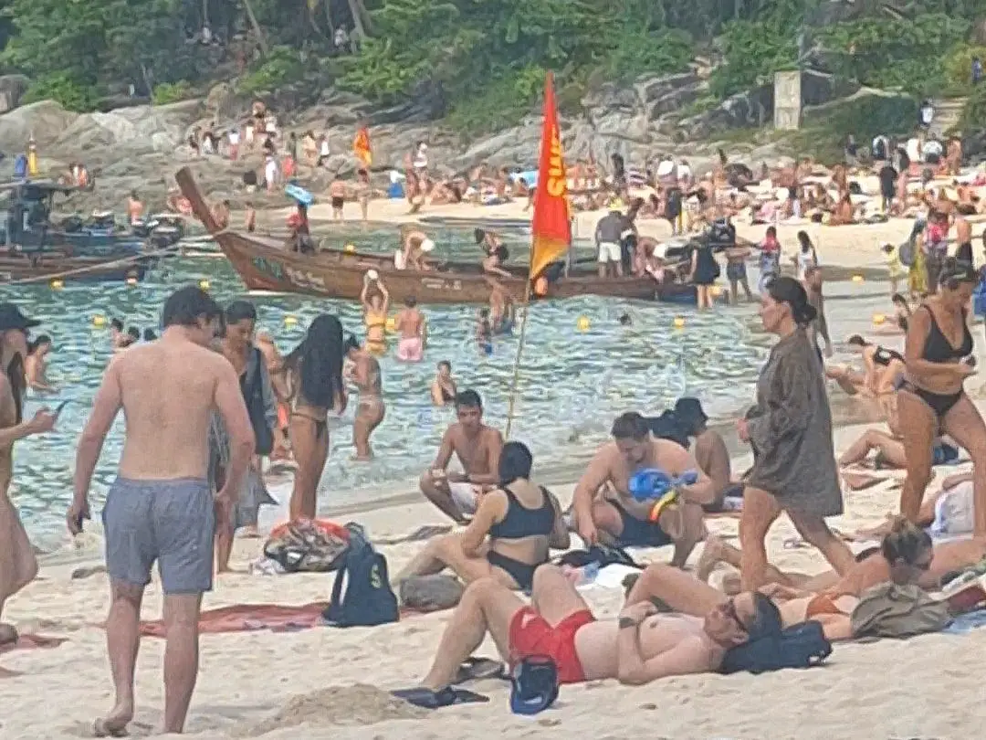 A beach with sunbathers in Phuket, Thailand.