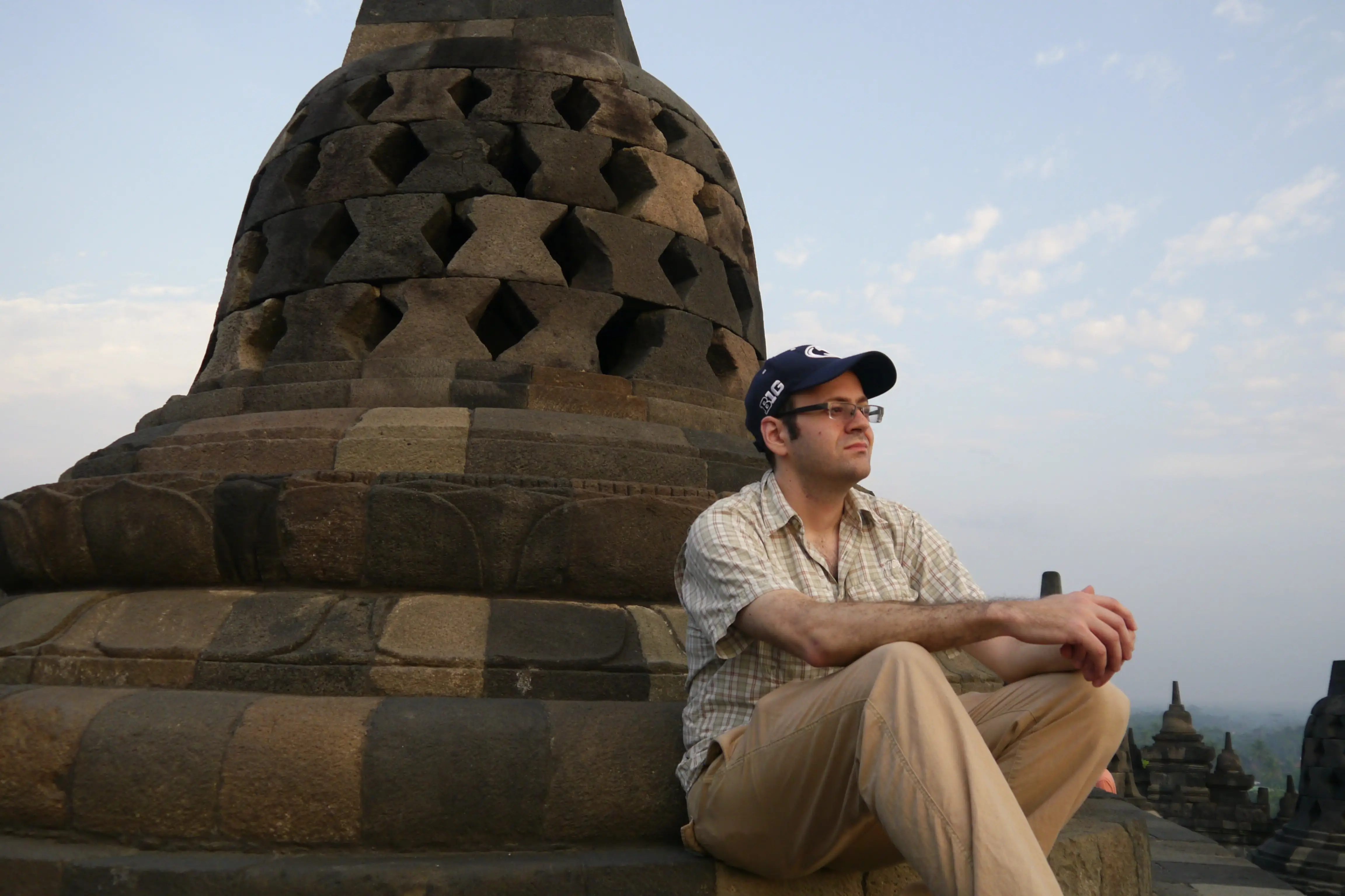 Author Matthew Lubin leaning on stone sculpture