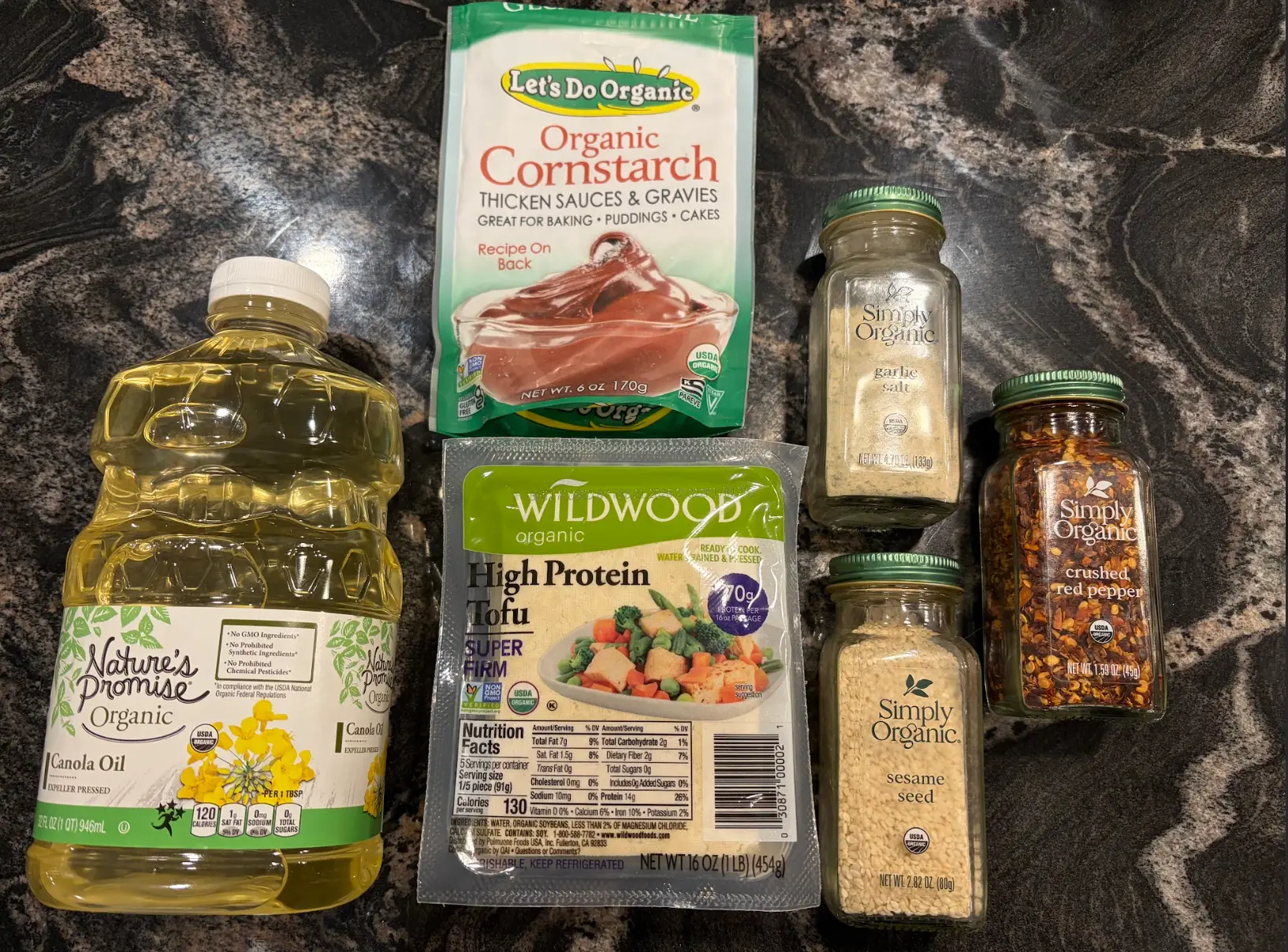 The ingredients needed to make Martha Stewart's crispy fried tofu: cornstarch, canola oil, spices, and extra-firm tofu.