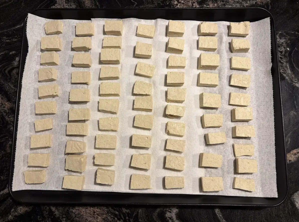 The writer draining tofu on a baking sheet.