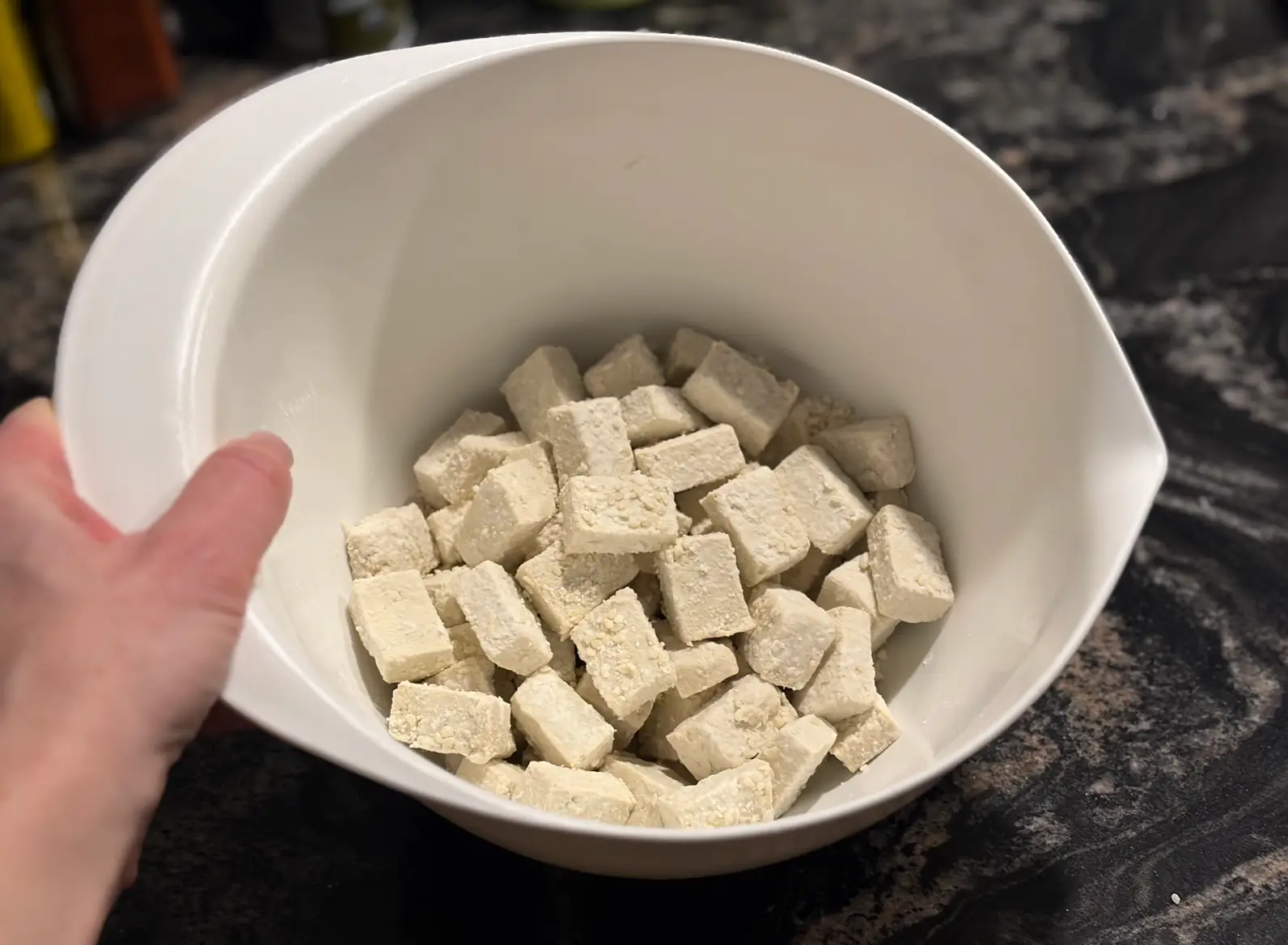 The writer dredging the tofu in a bowl.