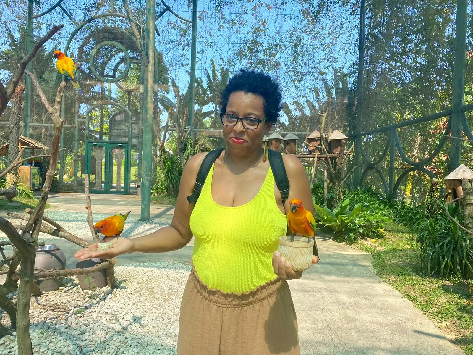 Author smiling with birds nearby and on her palms