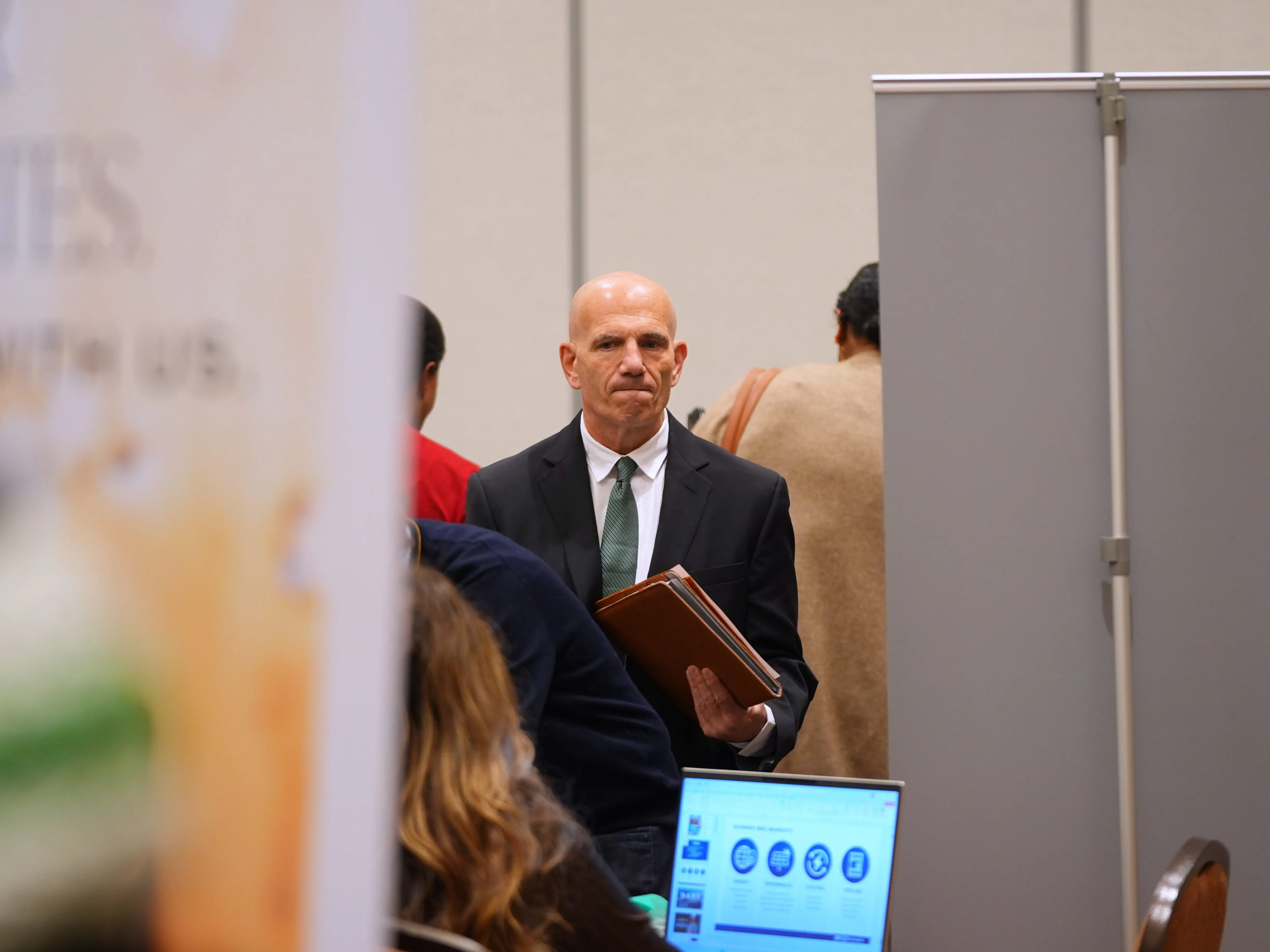 A man waits at a job fair