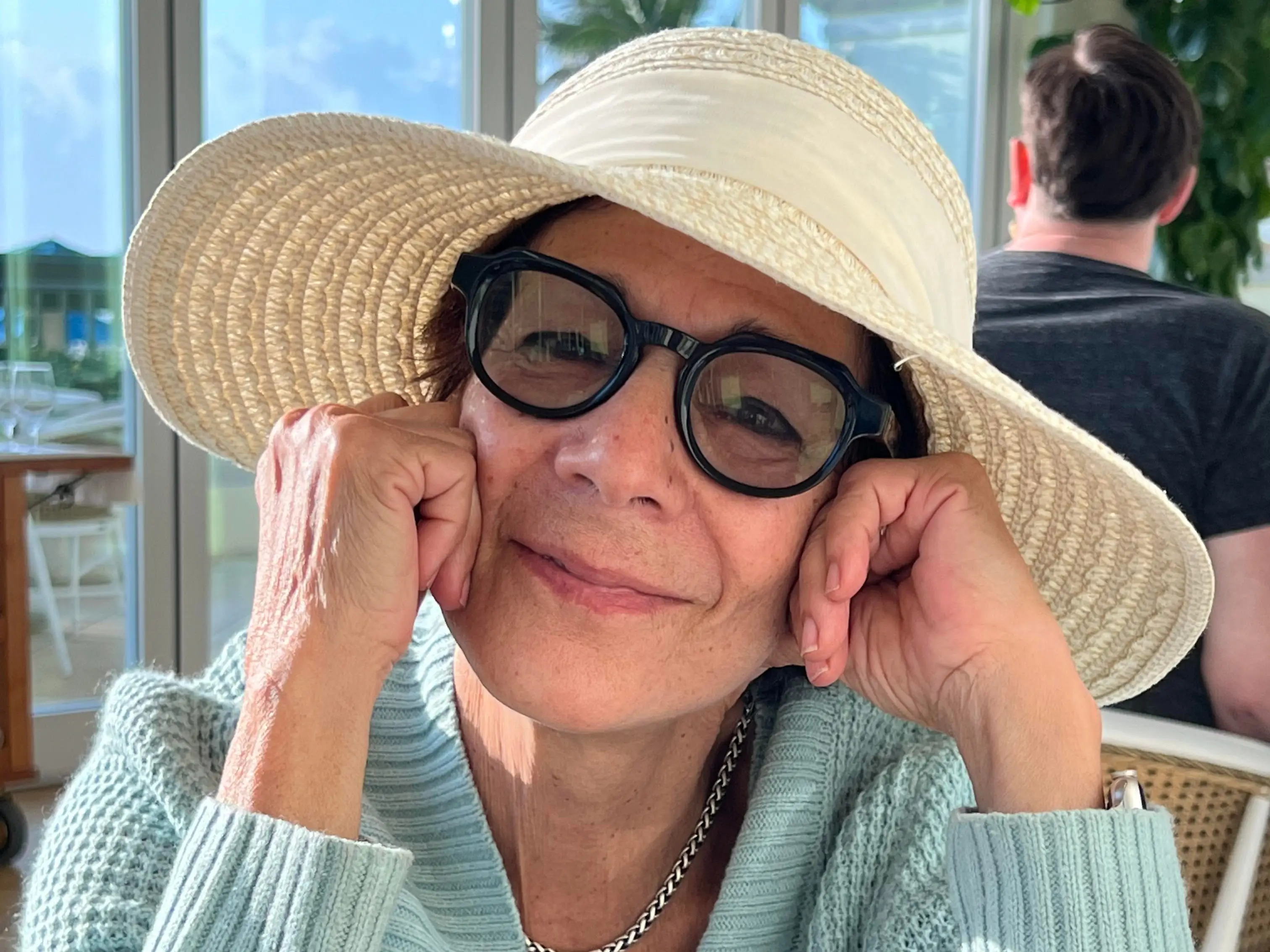 A senior wearing glasses and a hat