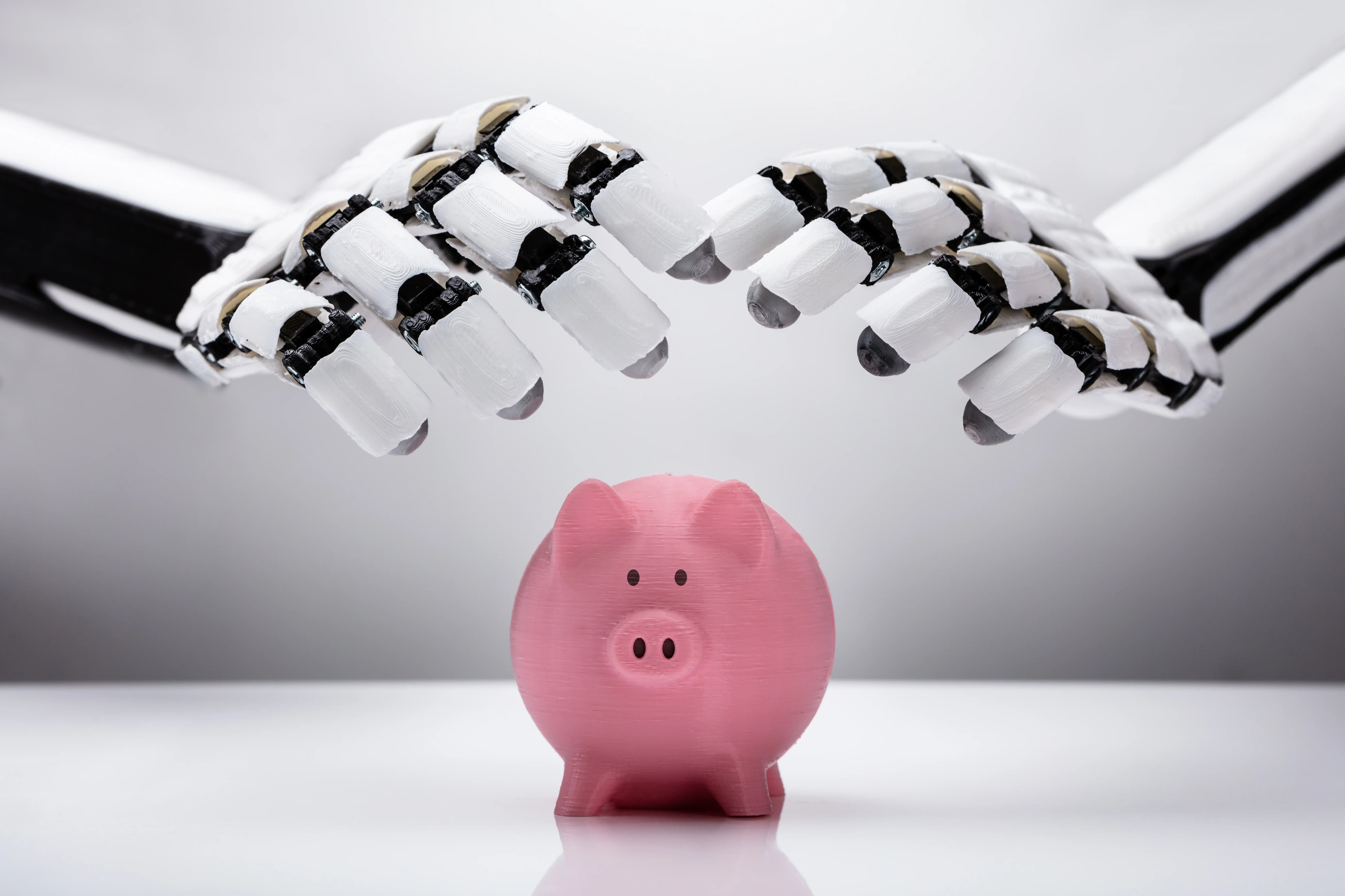 Robotic hands held over a piggy bank