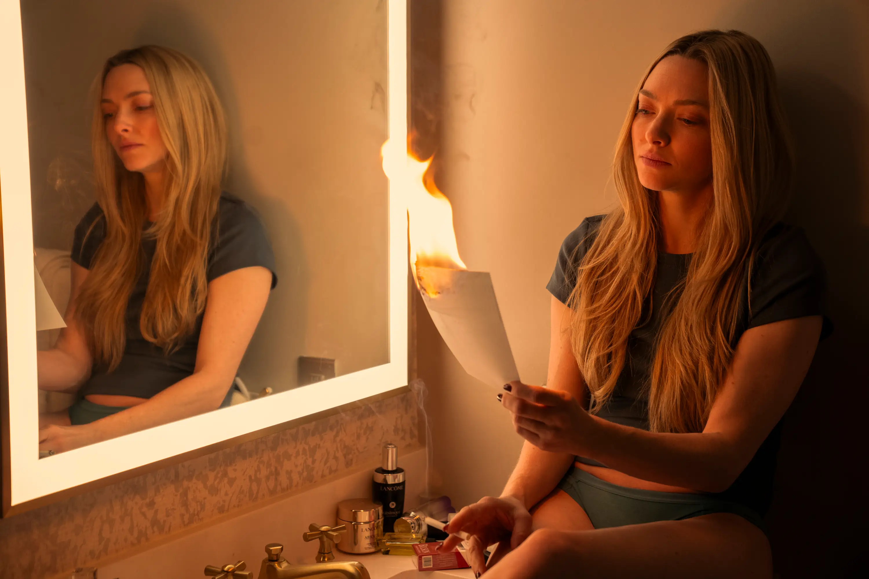 Amanda Seyfied burning a paper in The Housemaid