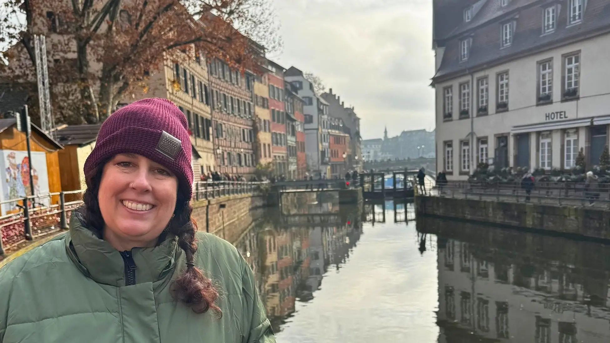 Author Chantelle Kincy smiling in front of water in Strasbourg, Alsace