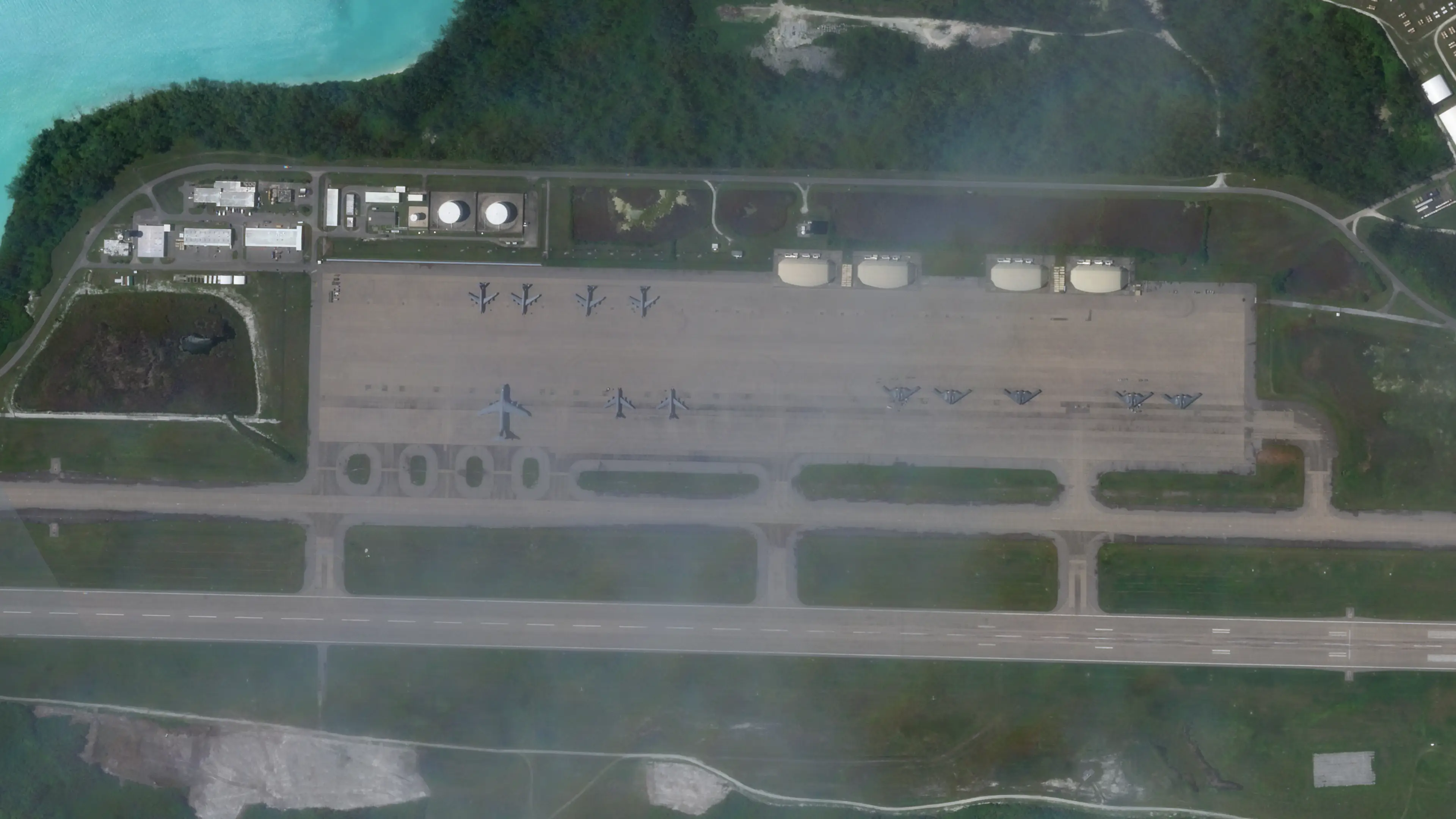 A satellite image showing aircraft parked on a tarmac at Diego Garcia. Greenery surrounds the base.