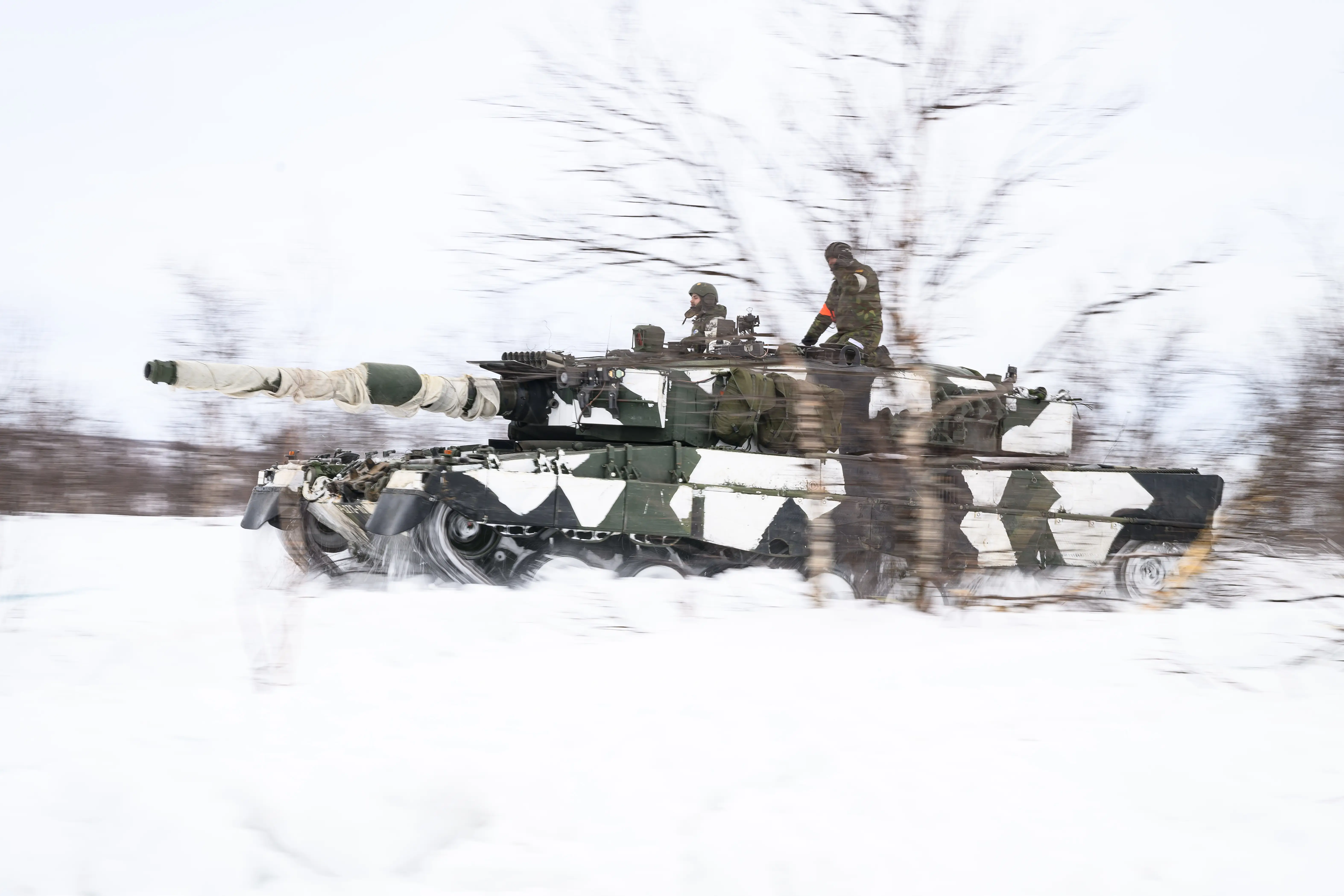 Figures drive on tanks in snow