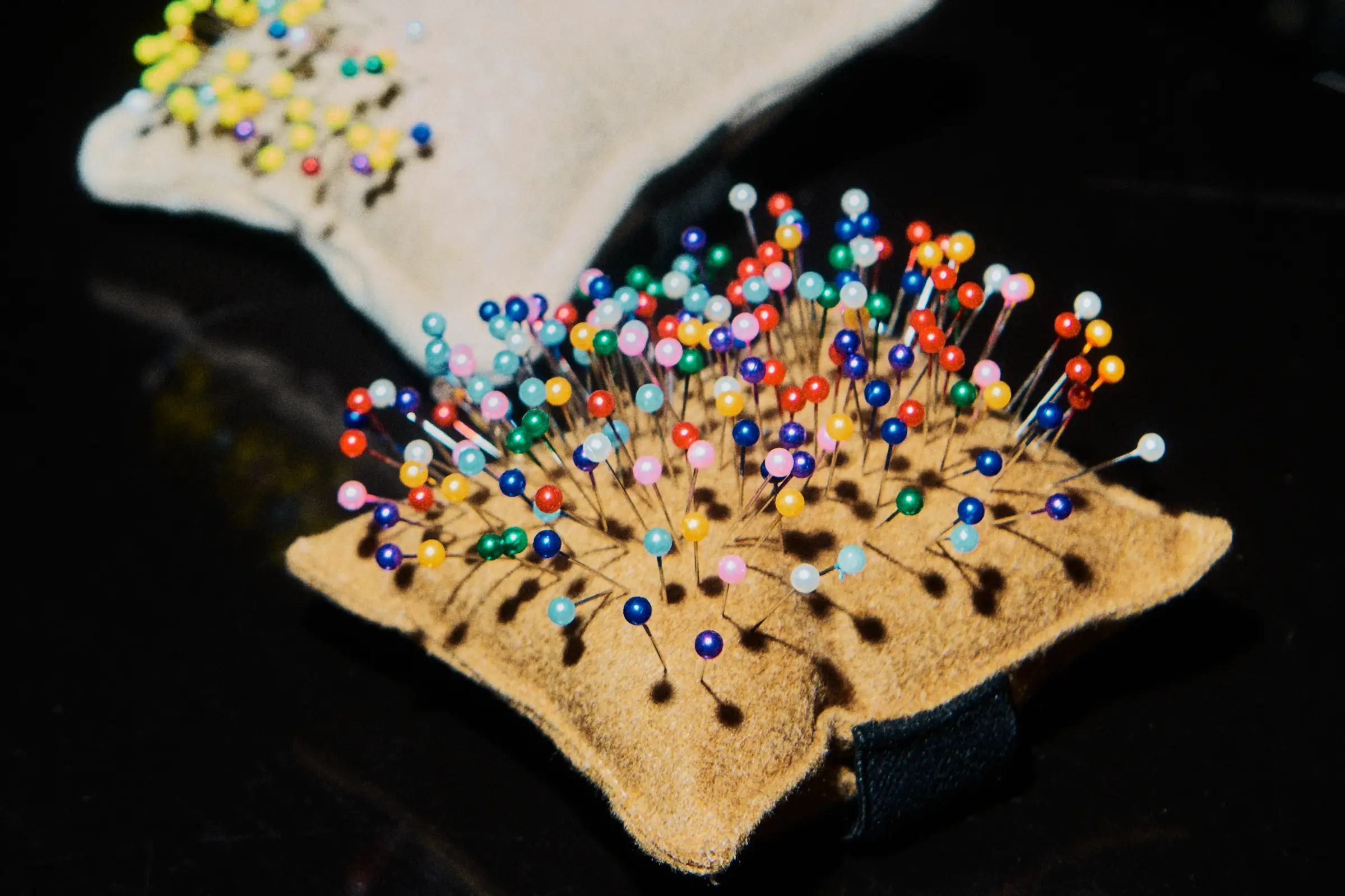 Sewing pushpins on a cushion.