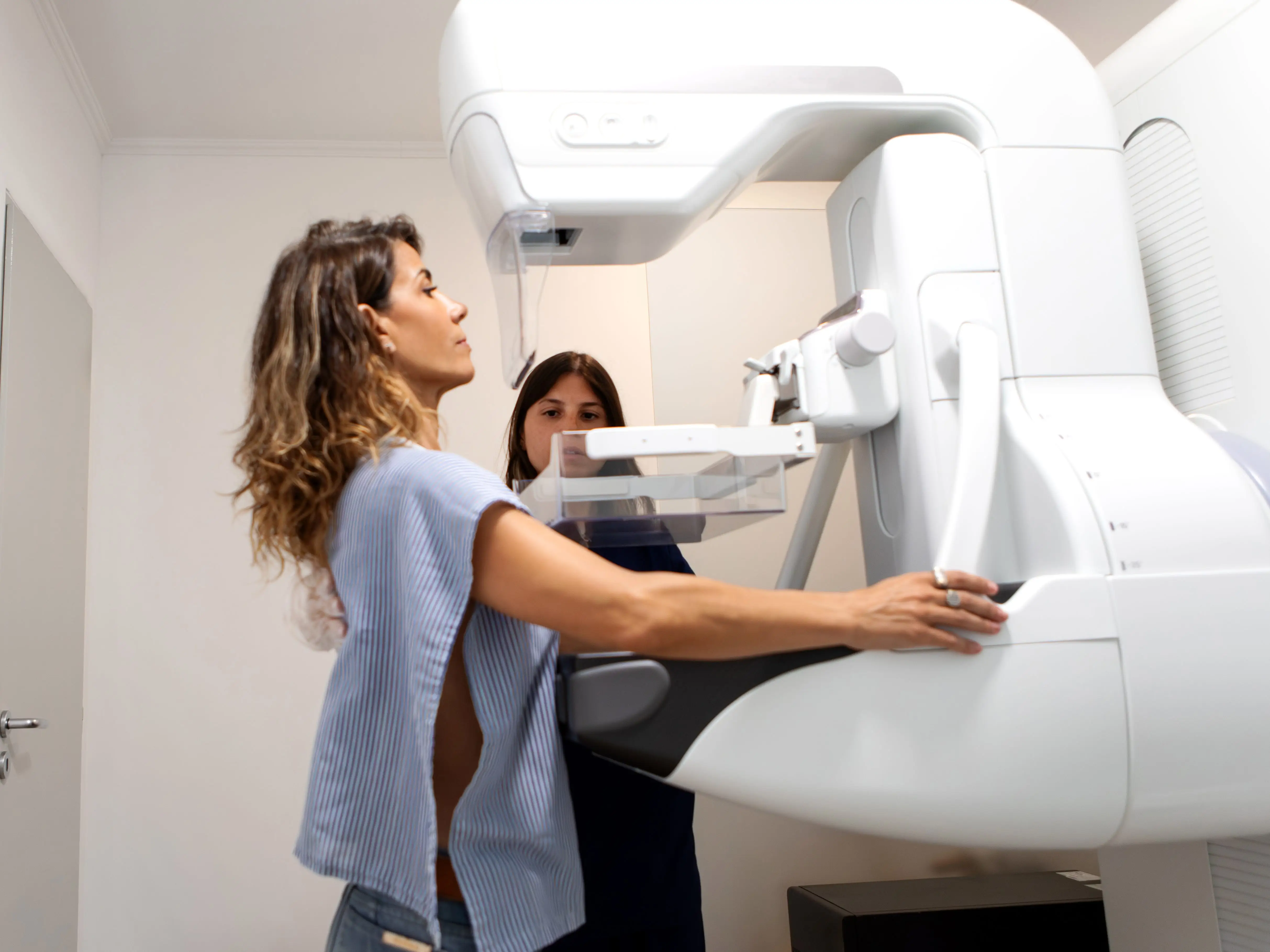 a woman undergoing a mammogram screening for breast cancer in a doctor's office