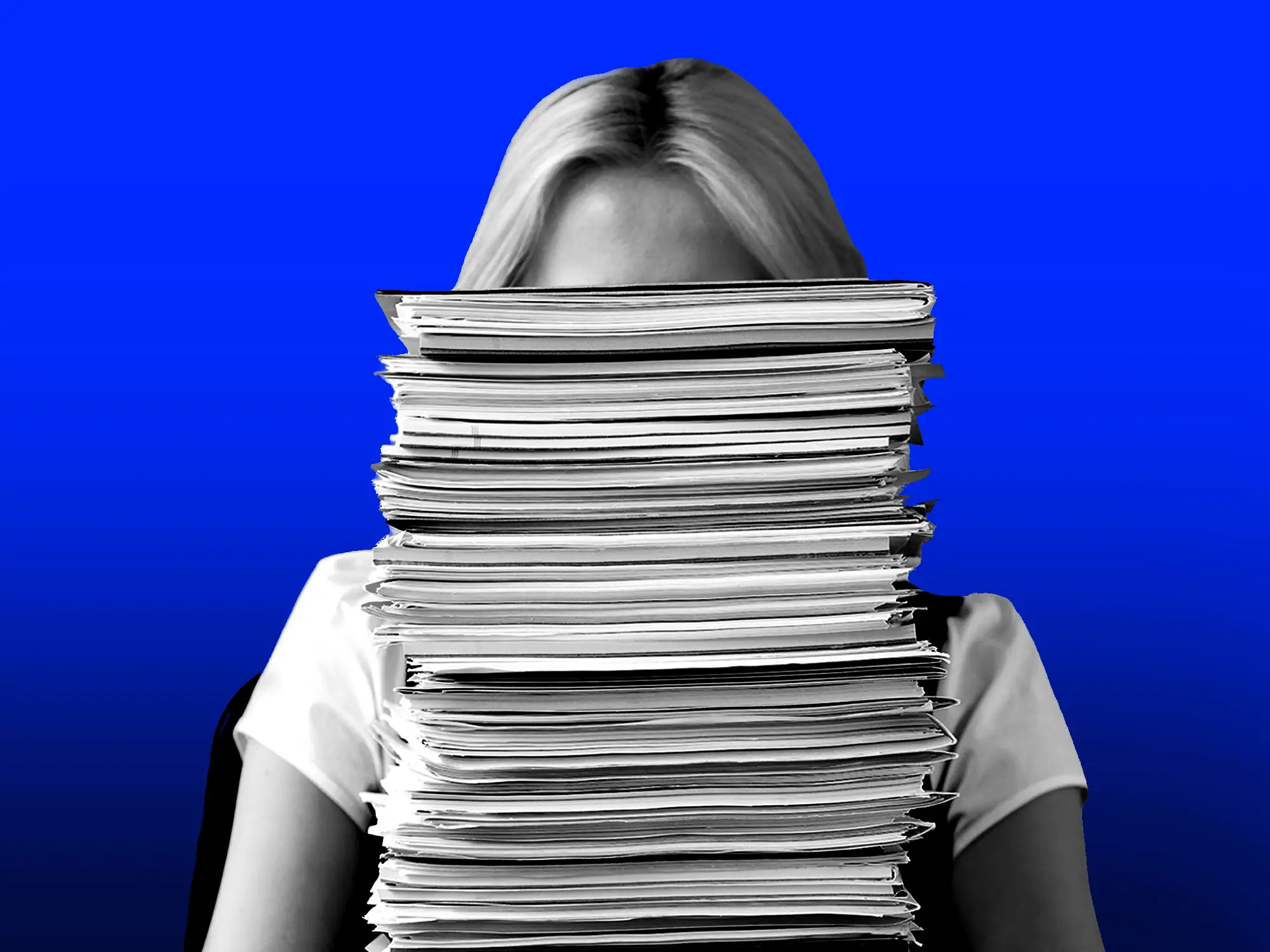 A woman is behind a stack of paperwork.