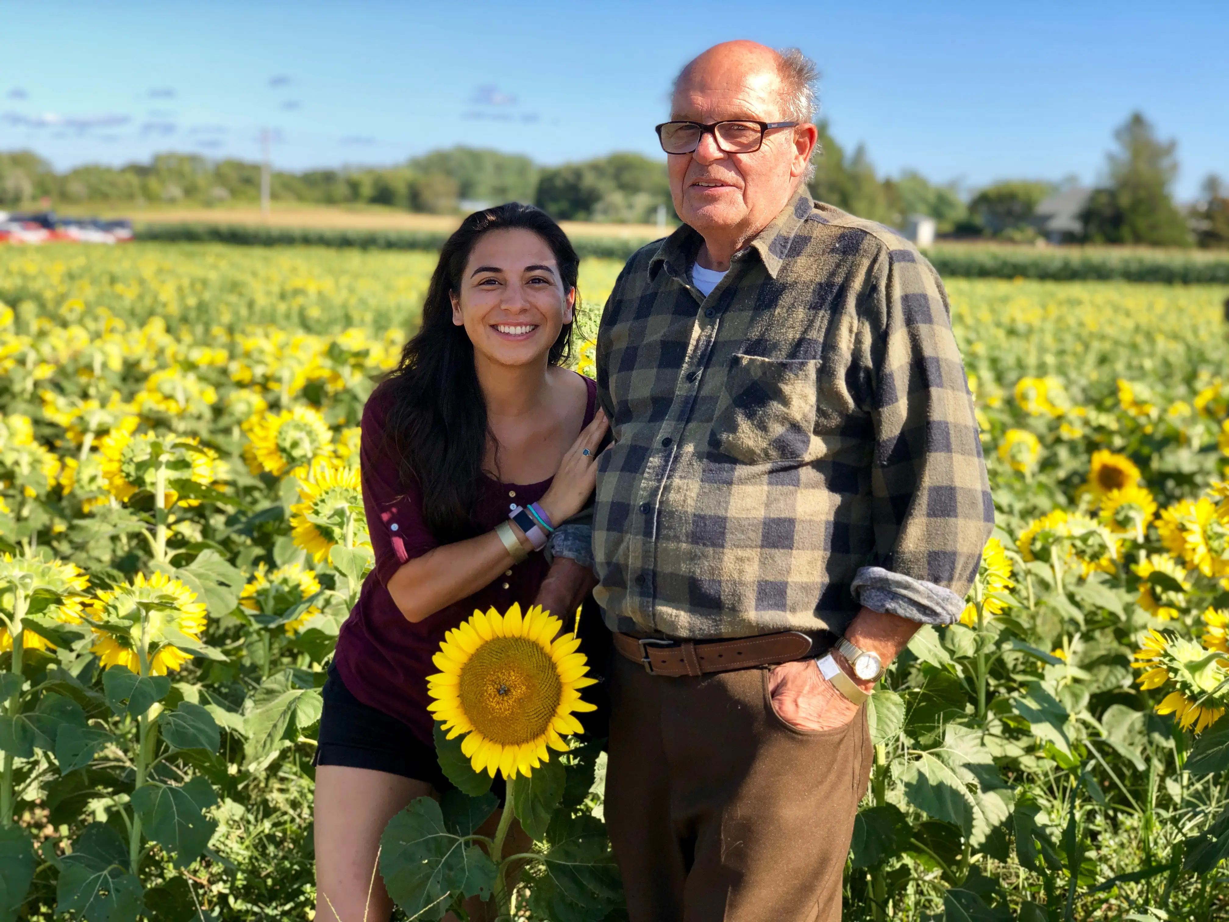 the author and grandfather standing in a sunflower field