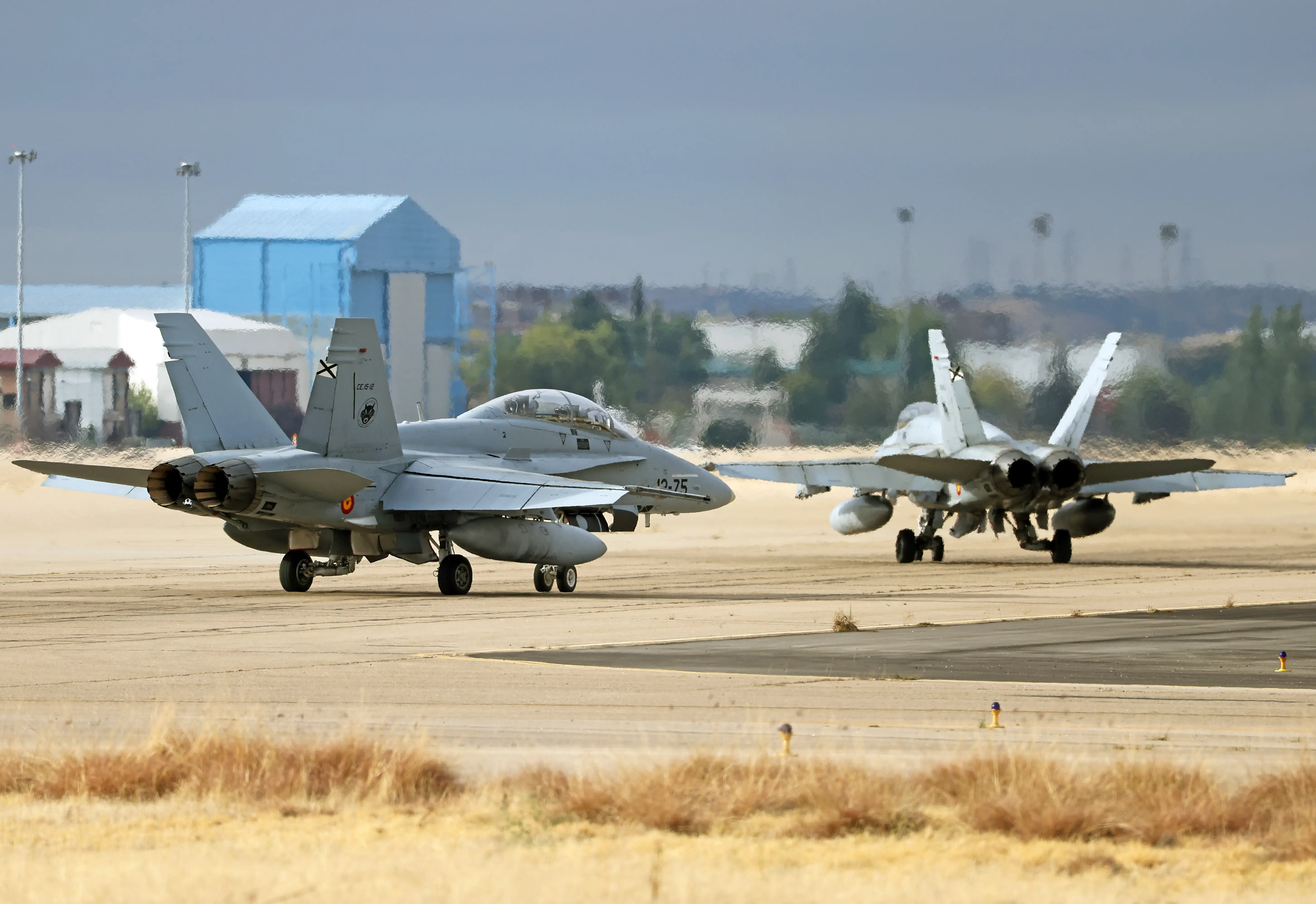 Two McDonnell Douglas EF-18B Hornets of the Spanish Air Force head toward the runway of the Torrejon de Ardoz military base in Madrid, Spain, on October 12, 2025.