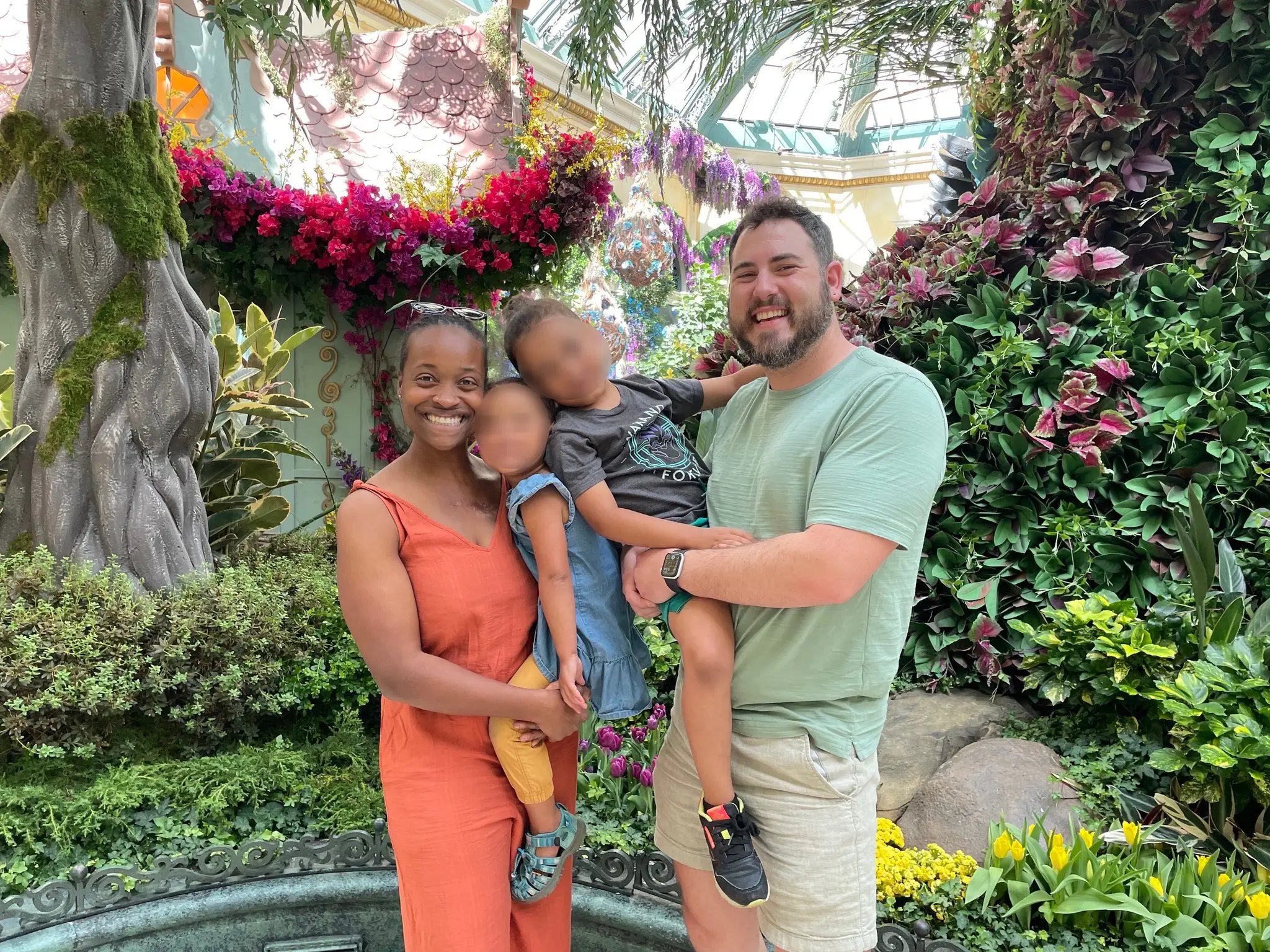 A family of four standing inside a conservatory.