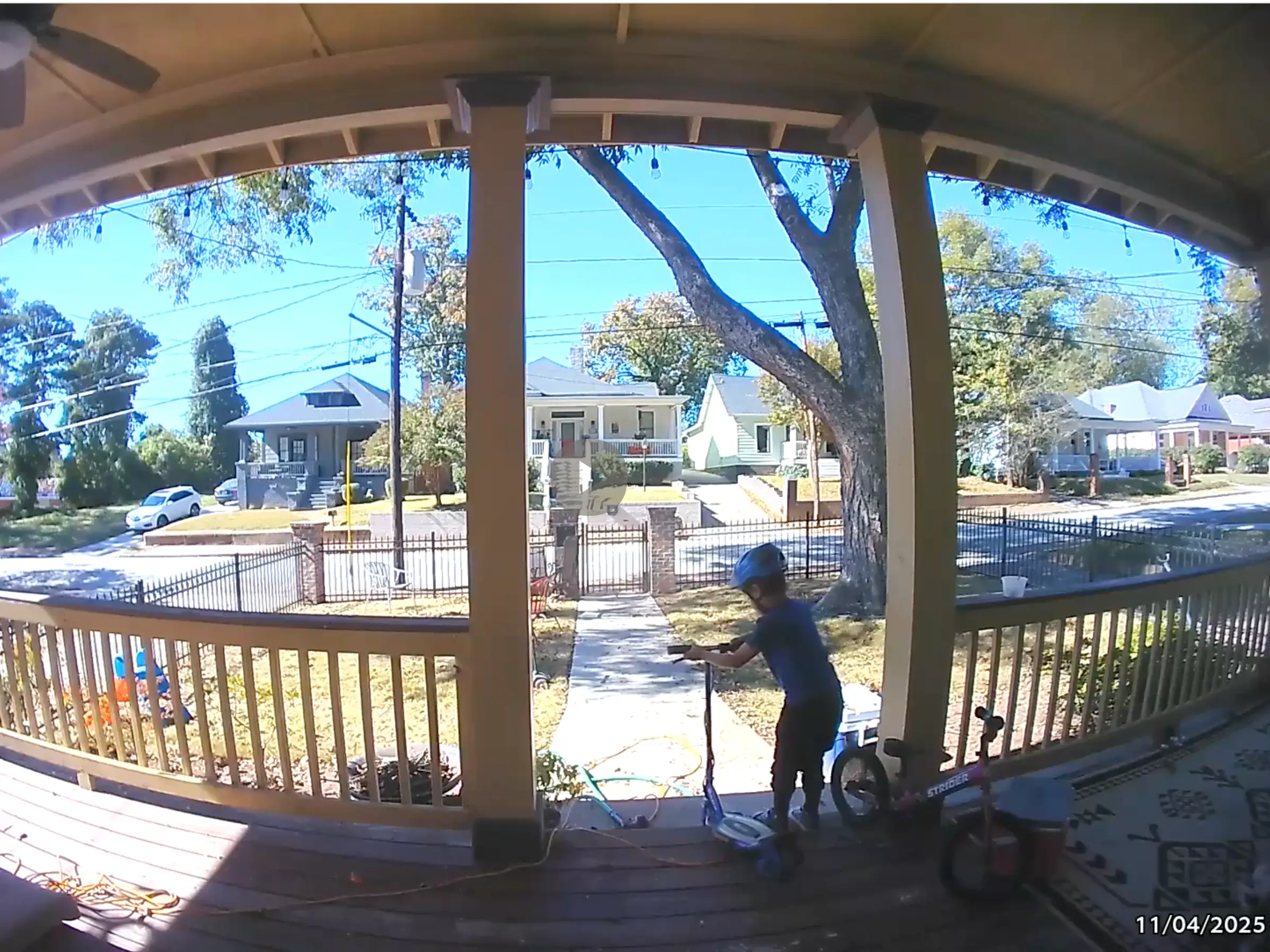 A still from a ring camera showing a little boy preparing to get on an electric scooter